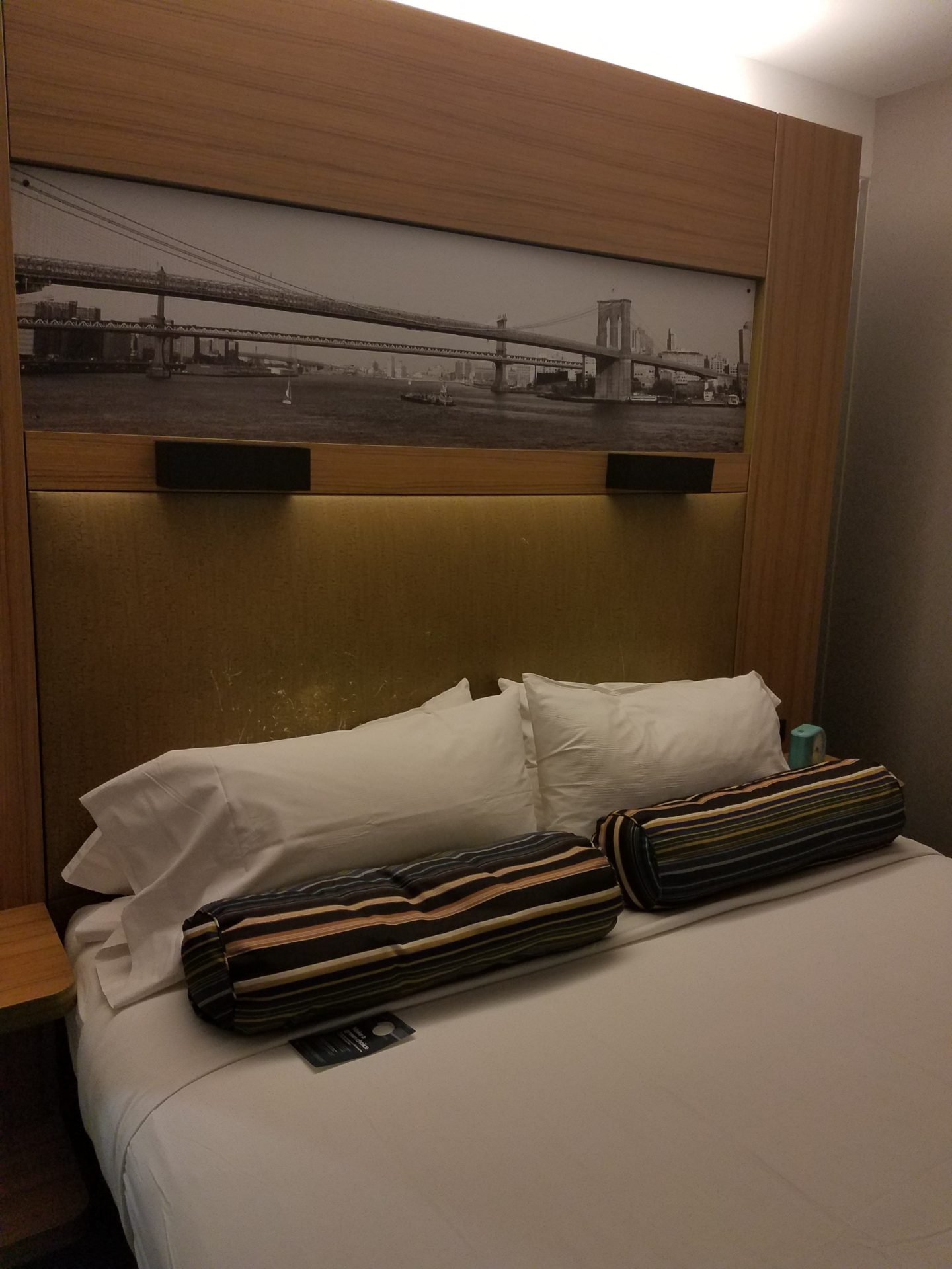 a bed with pillows and a picture of a bridge