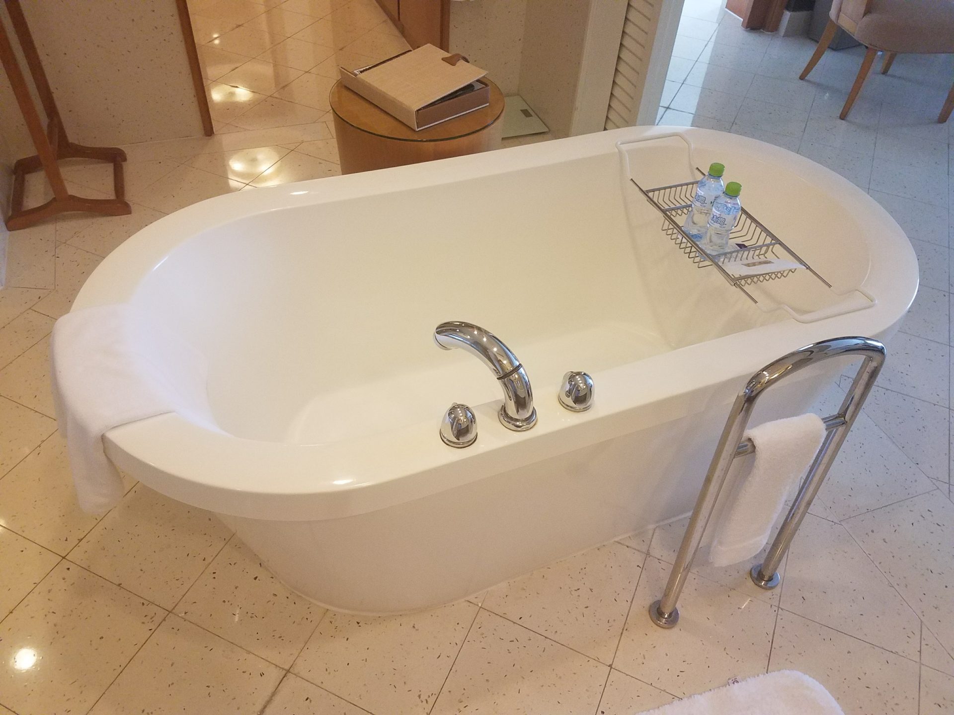 a bathtub with a towel rack and bottles on it