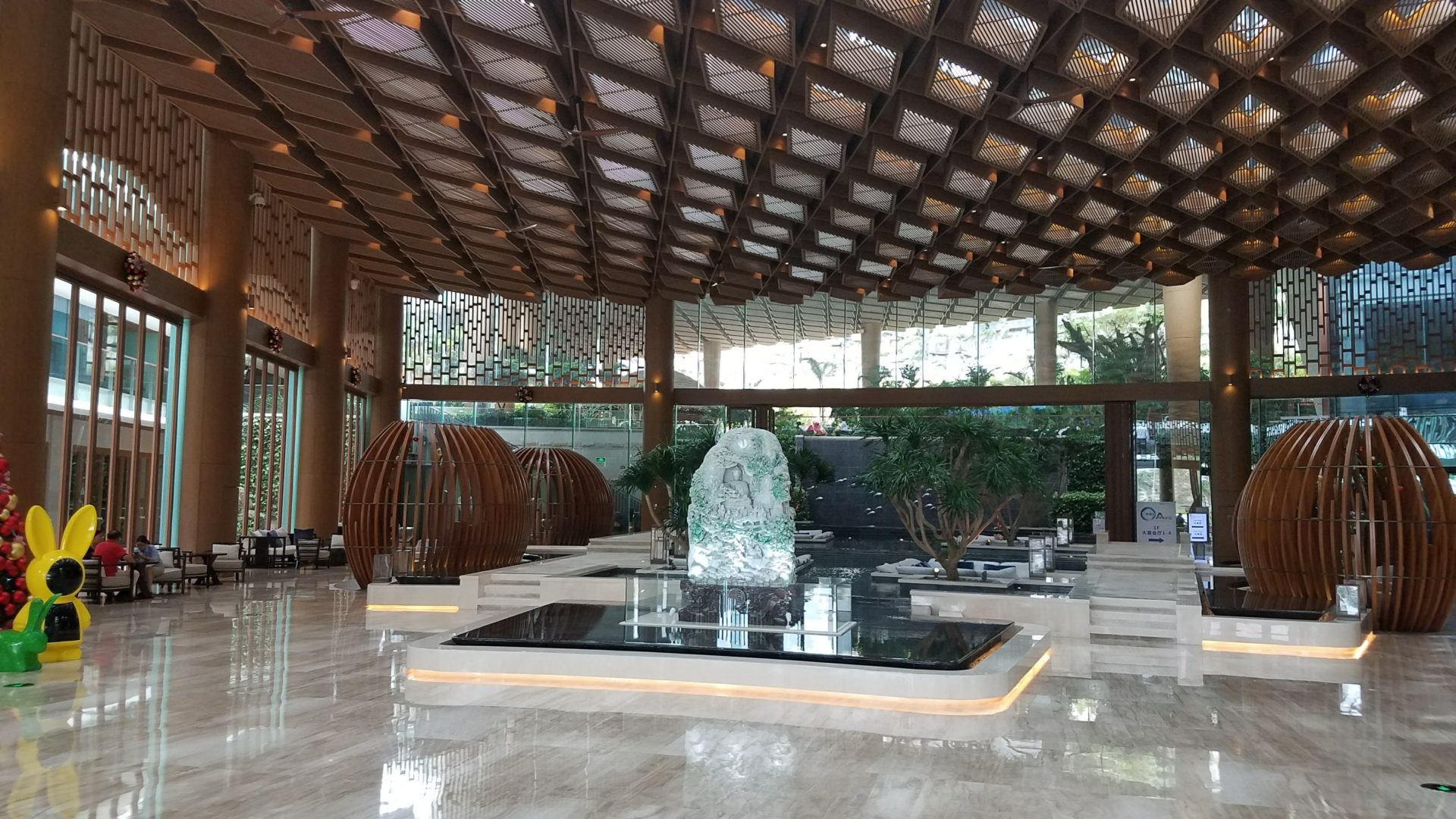a large room with a glass fountain and a large glass ceiling