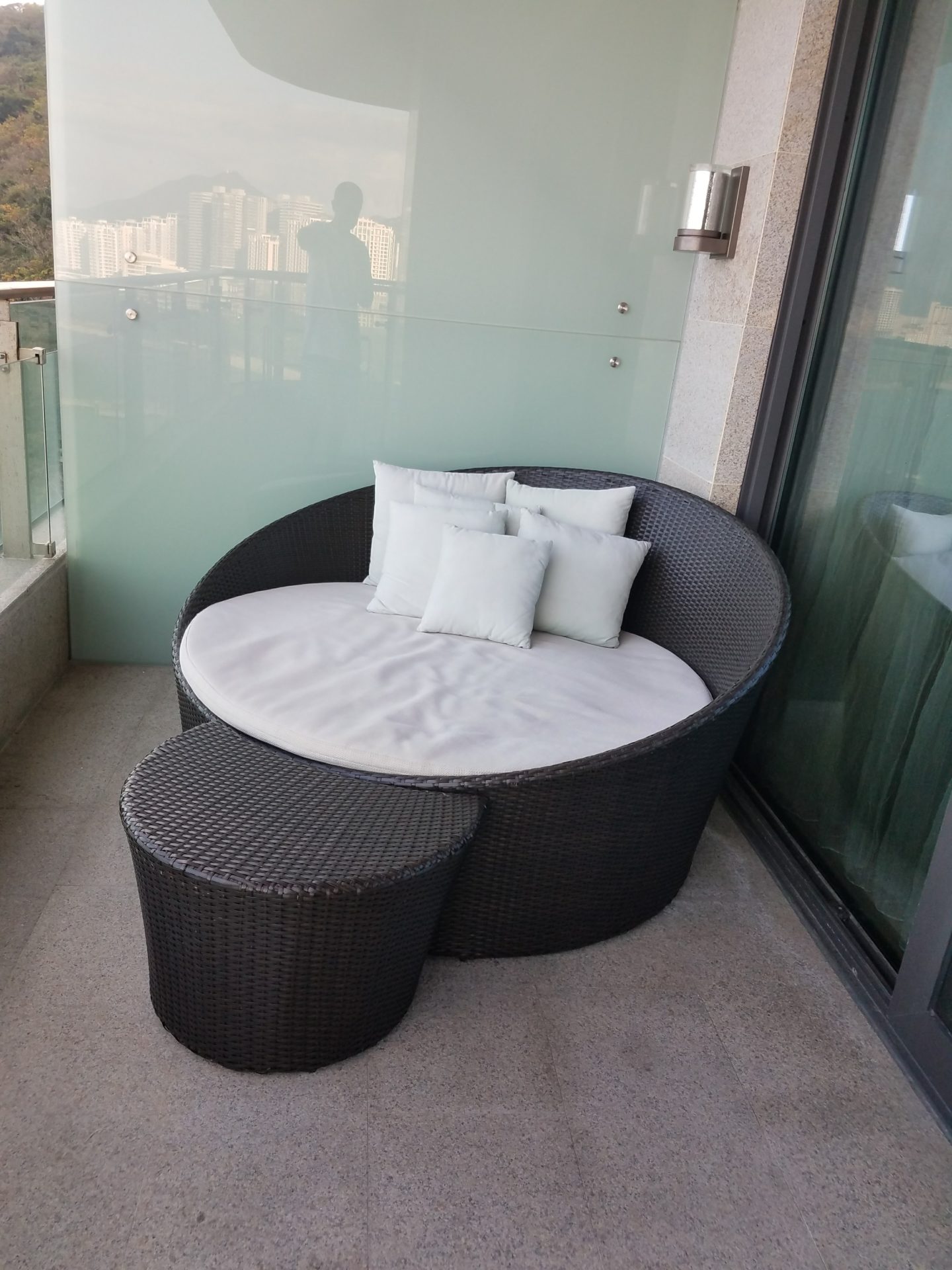 a round chair with pillows on a balcony