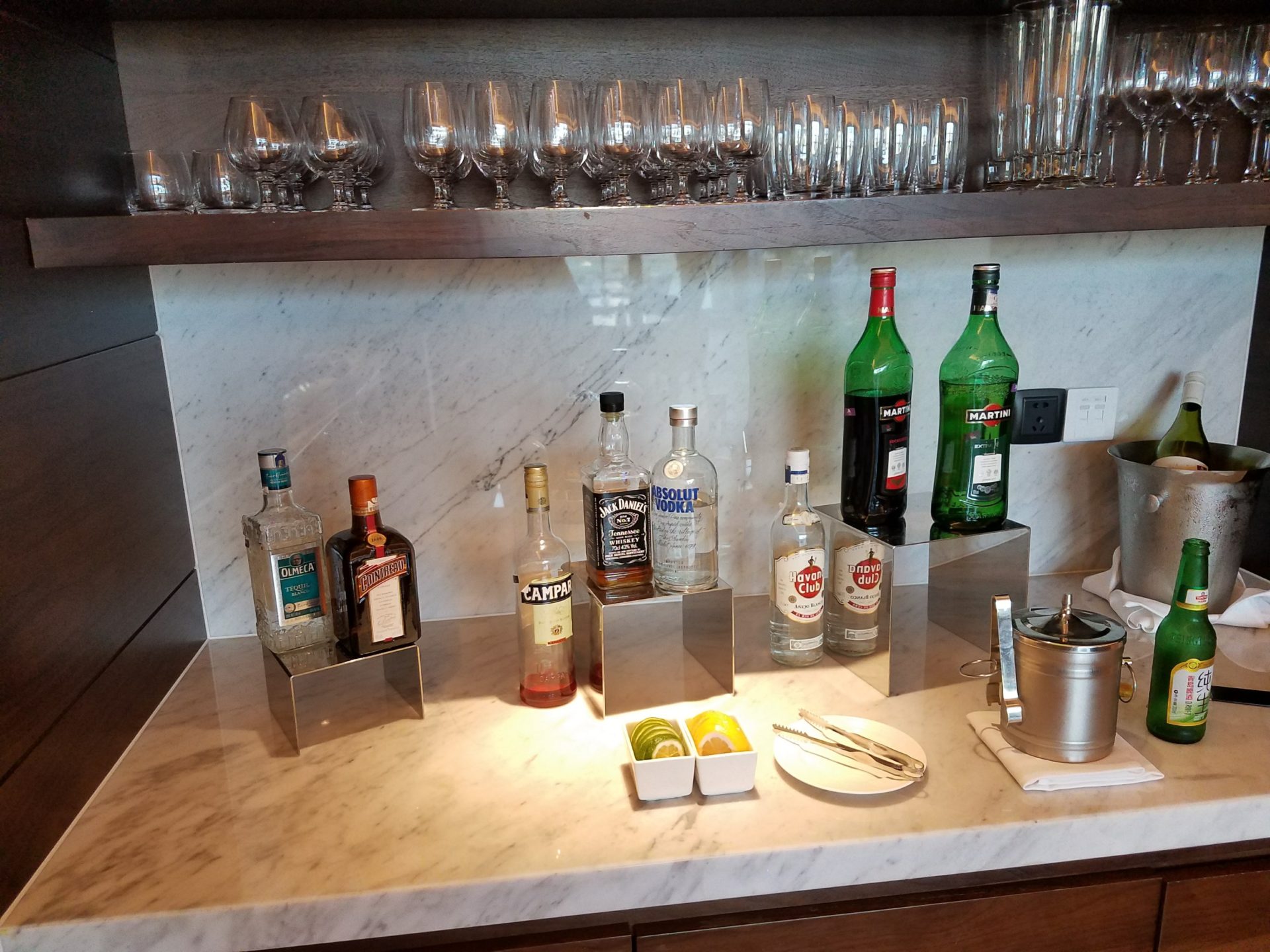 a bar with bottles of alcohol and glasses on the counter