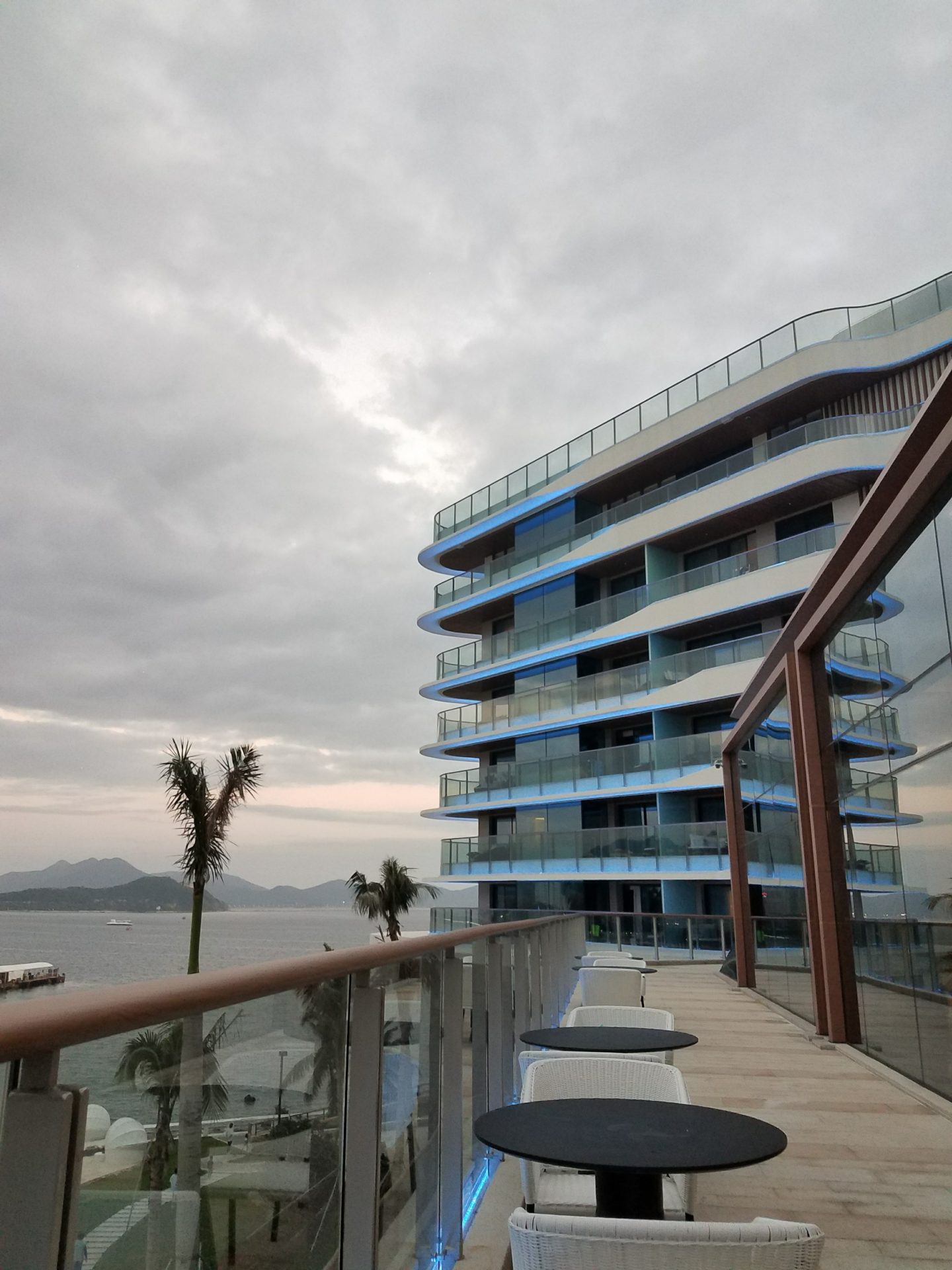 a balcony with a large building and a body of water