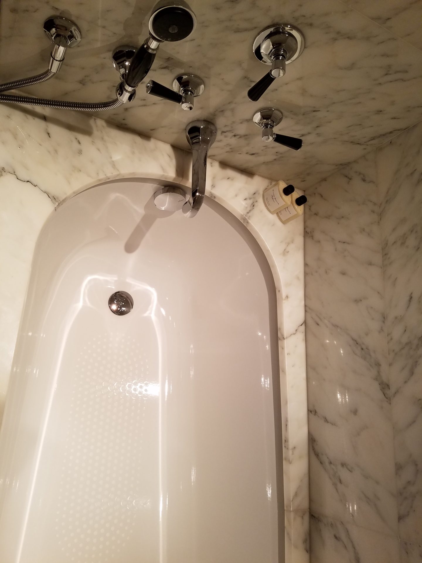 a bathtub with faucets and a shower head