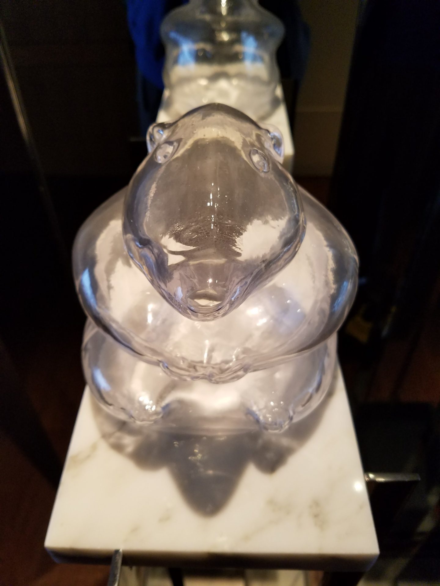 a glass bear sculpture on a marble surface