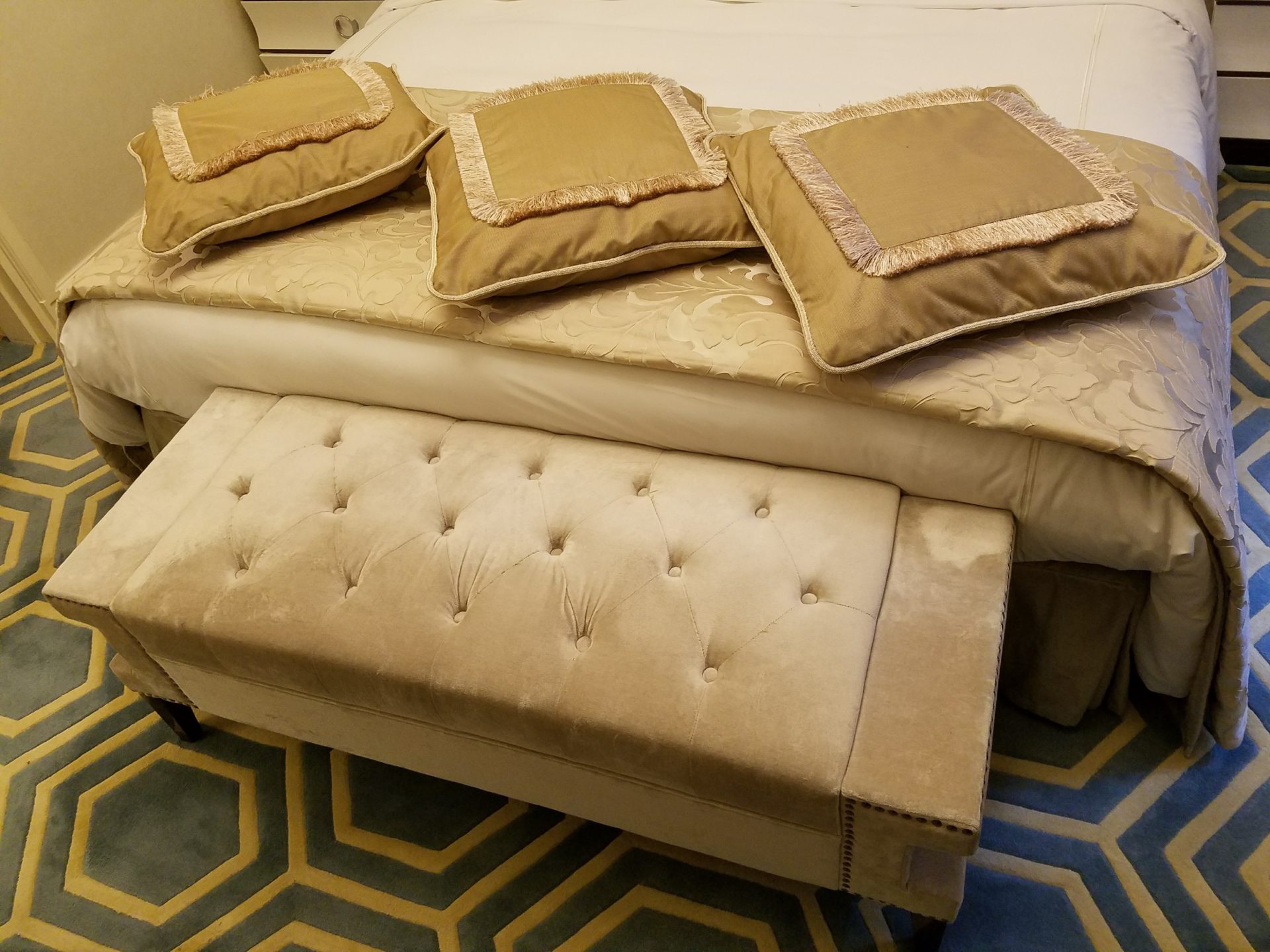 a bed with pillows on top of a bench