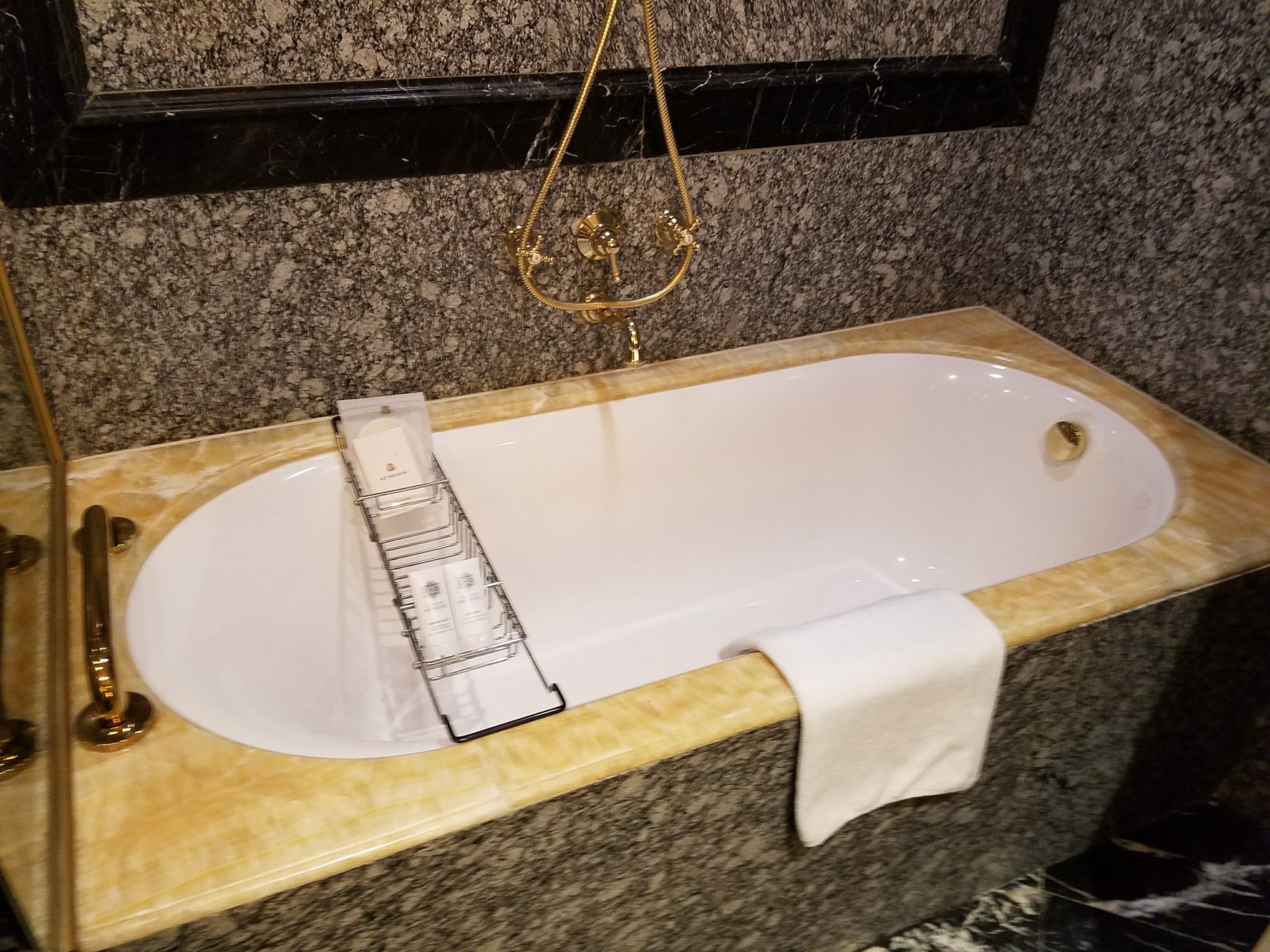 a bathtub with a towel from the wall