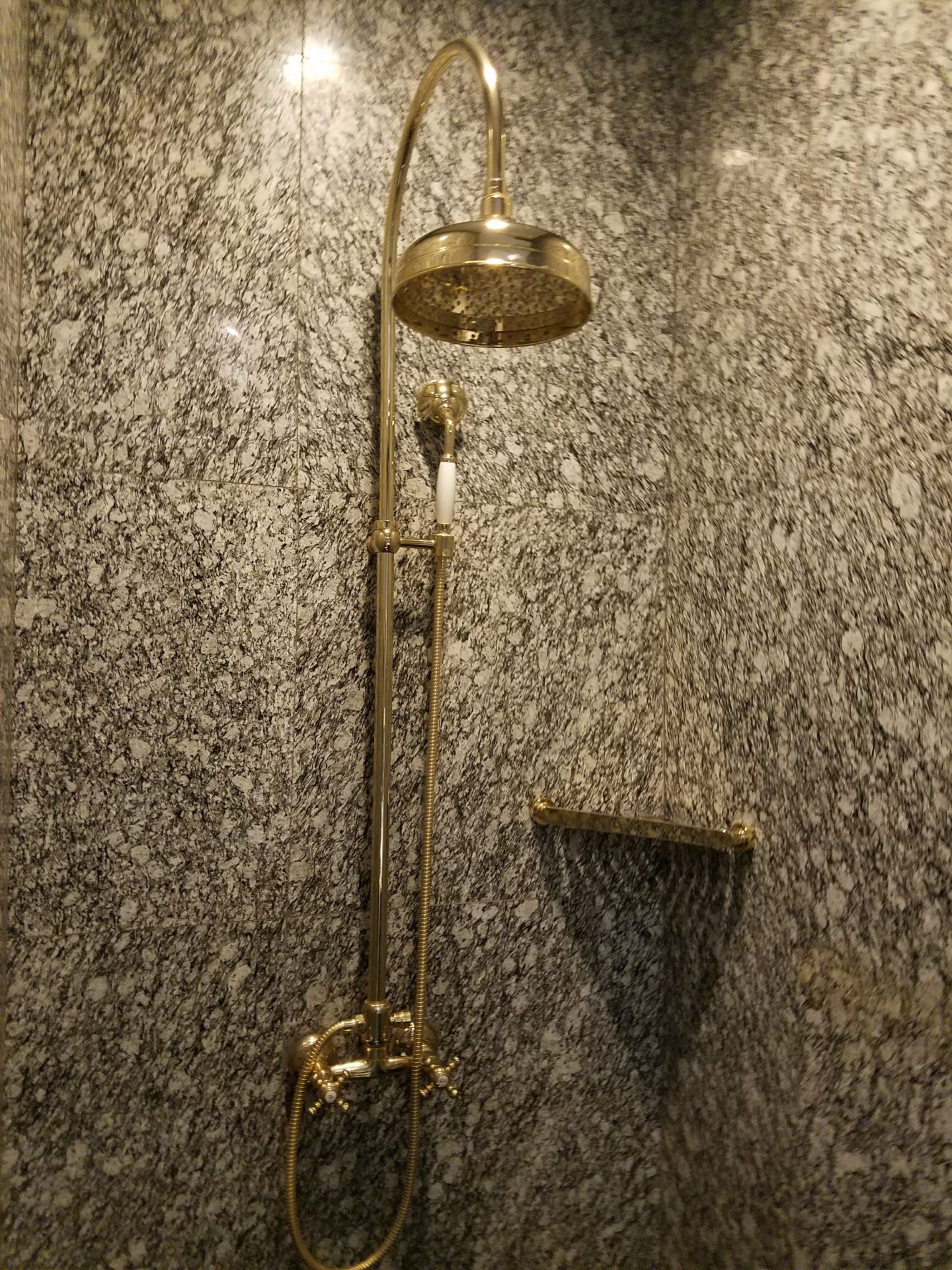 a shower with a gold shower head