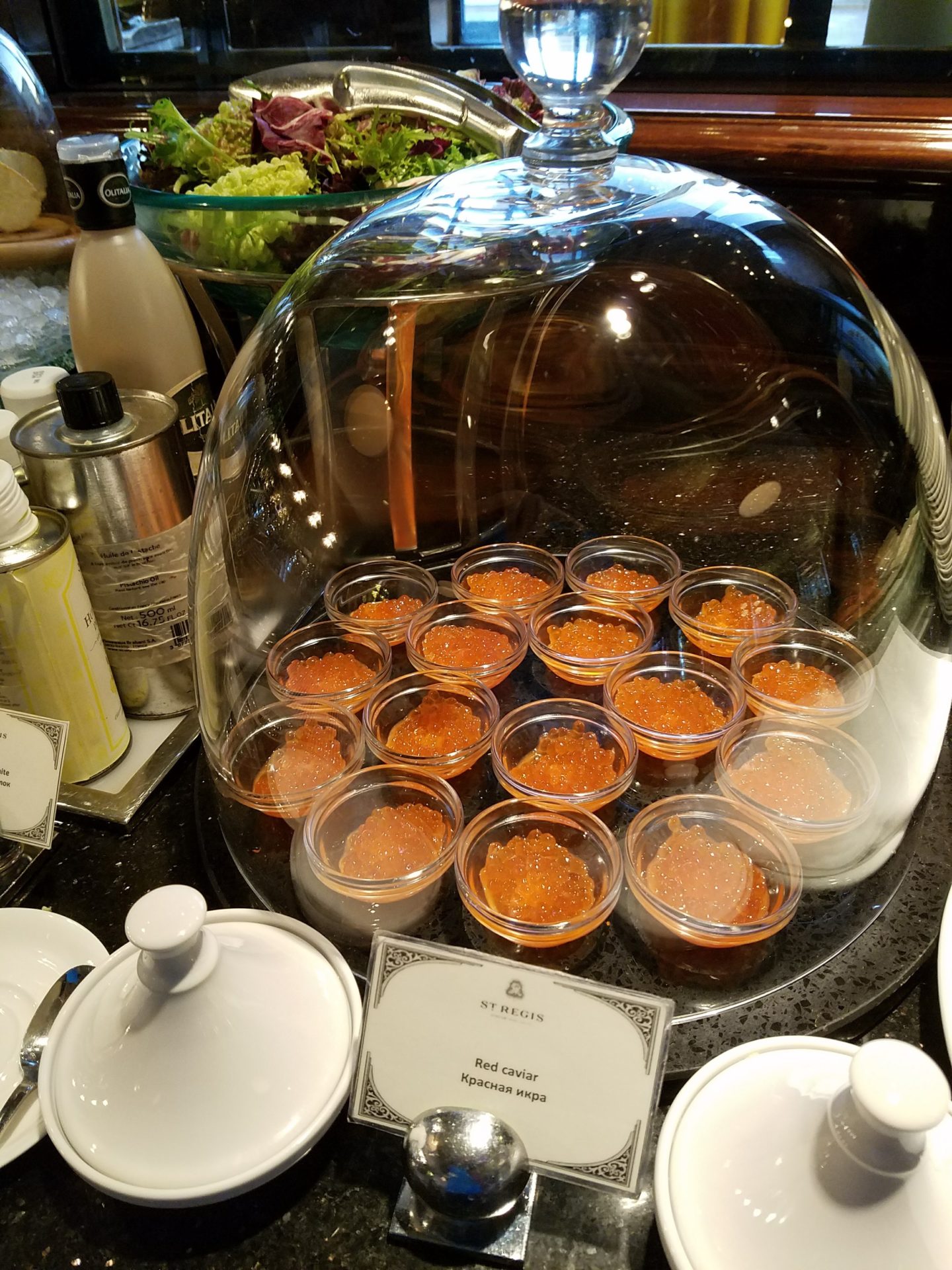 a group of small bowls of red caviar in a glass dome