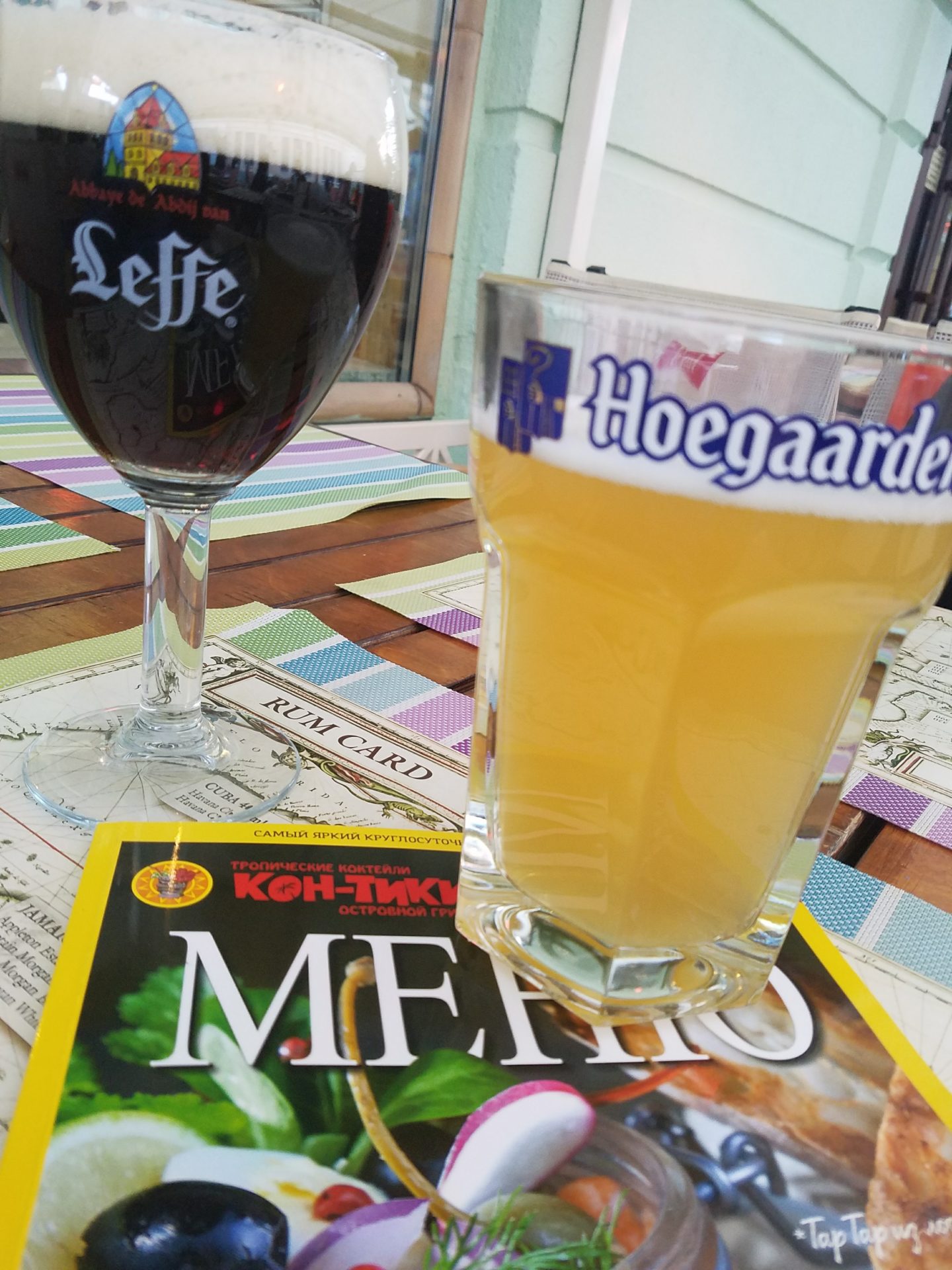 a glass of beer next to a magazine