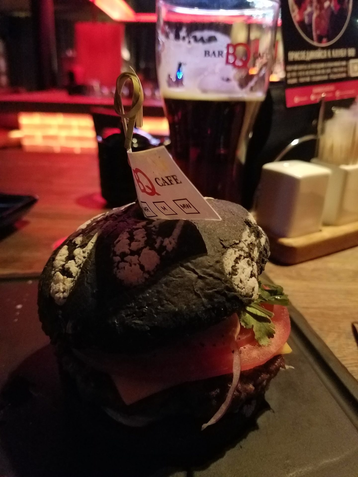 a burger on a plate with a glass of beer