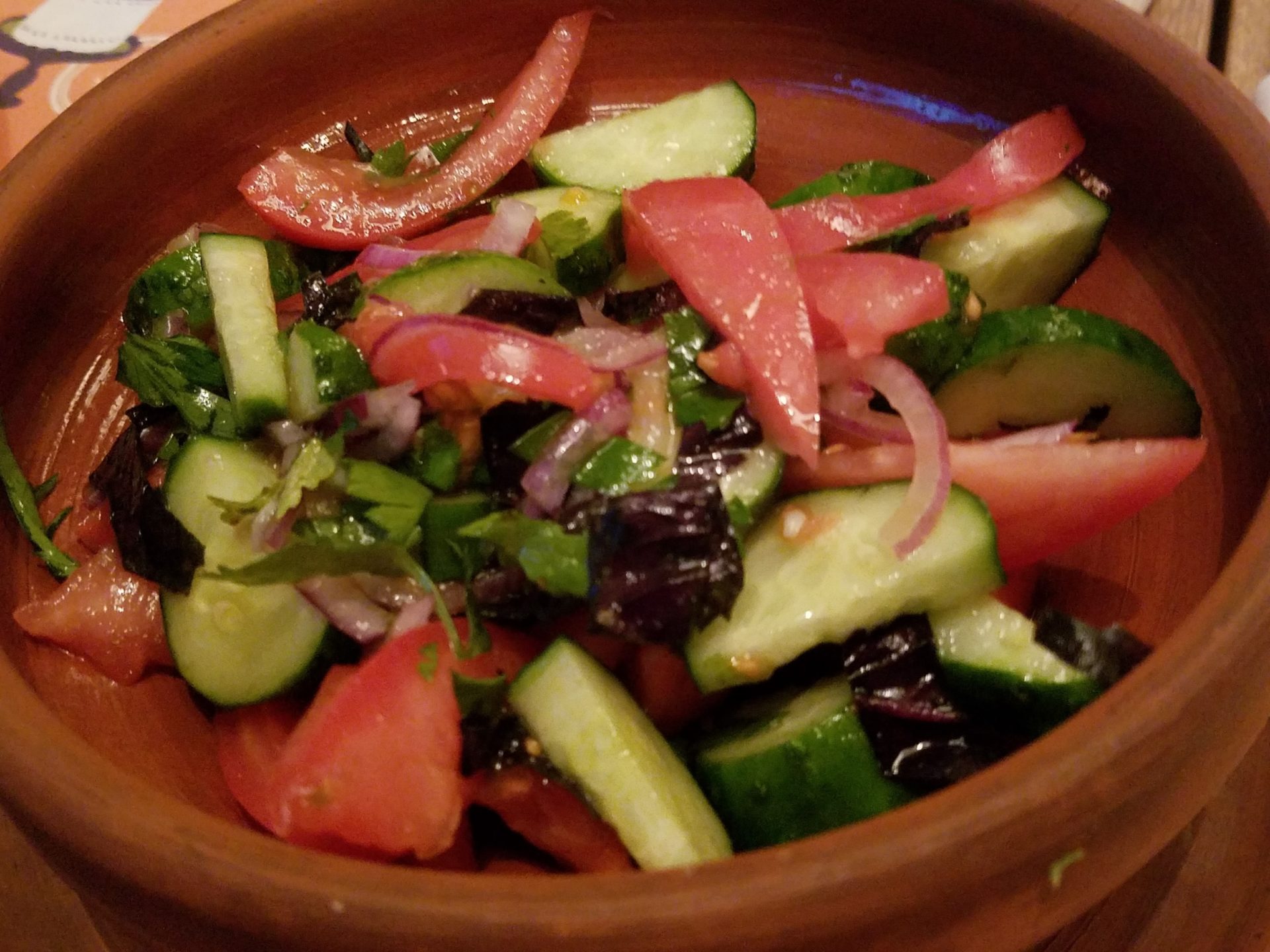 a bowl of salad with tomatoes and cucumbers