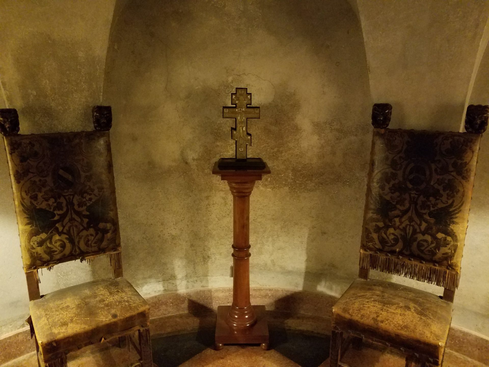a cross on a stand in a room with chairs