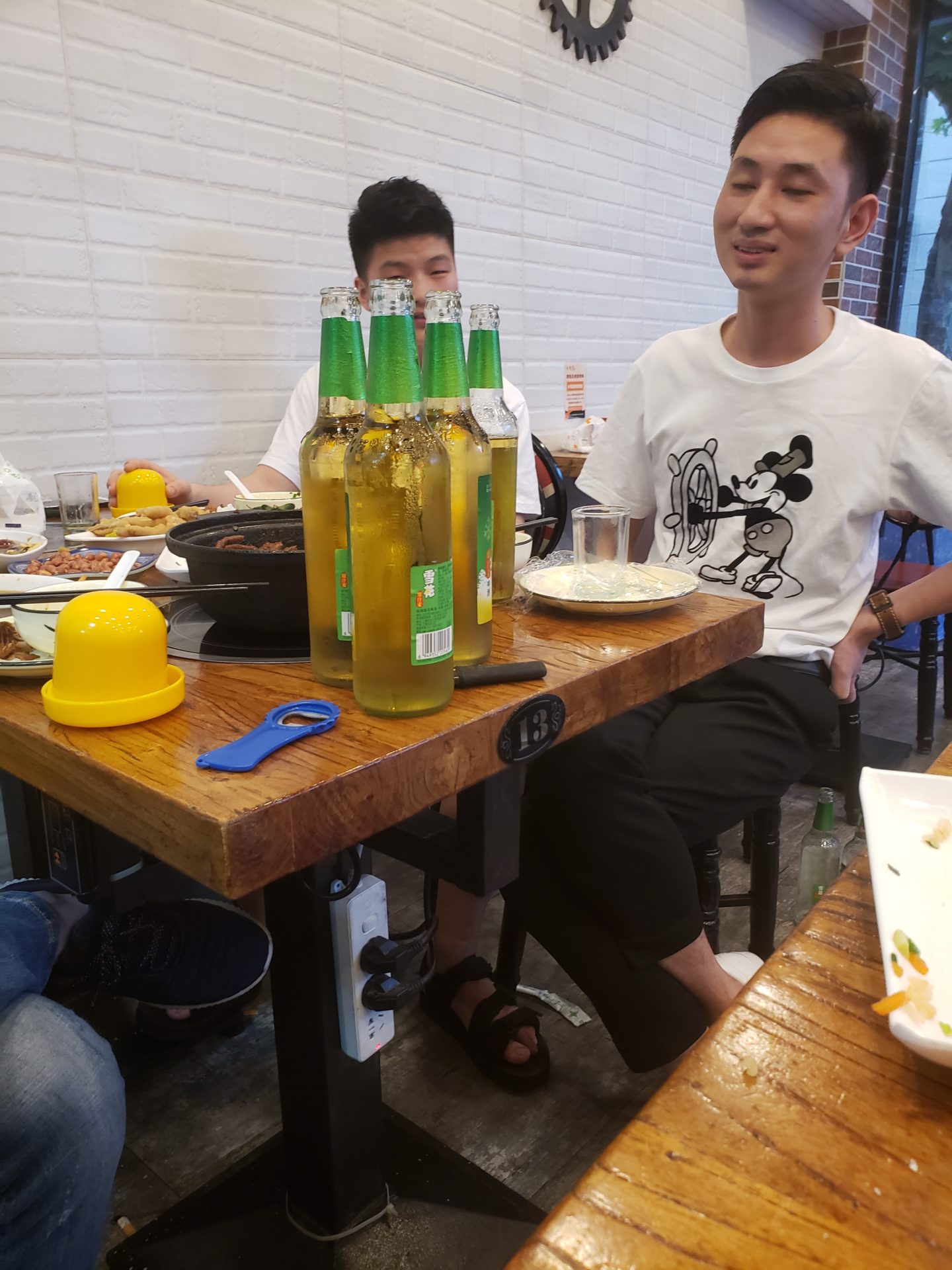 a group of people sitting at a table with bottles of beer