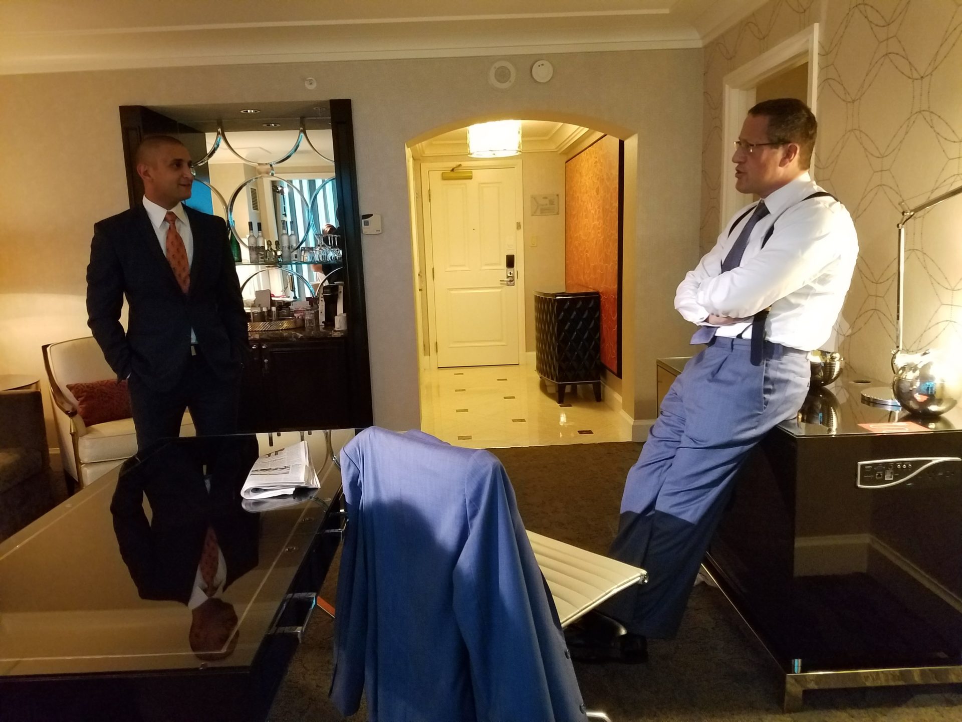 two men in suits standing in a room