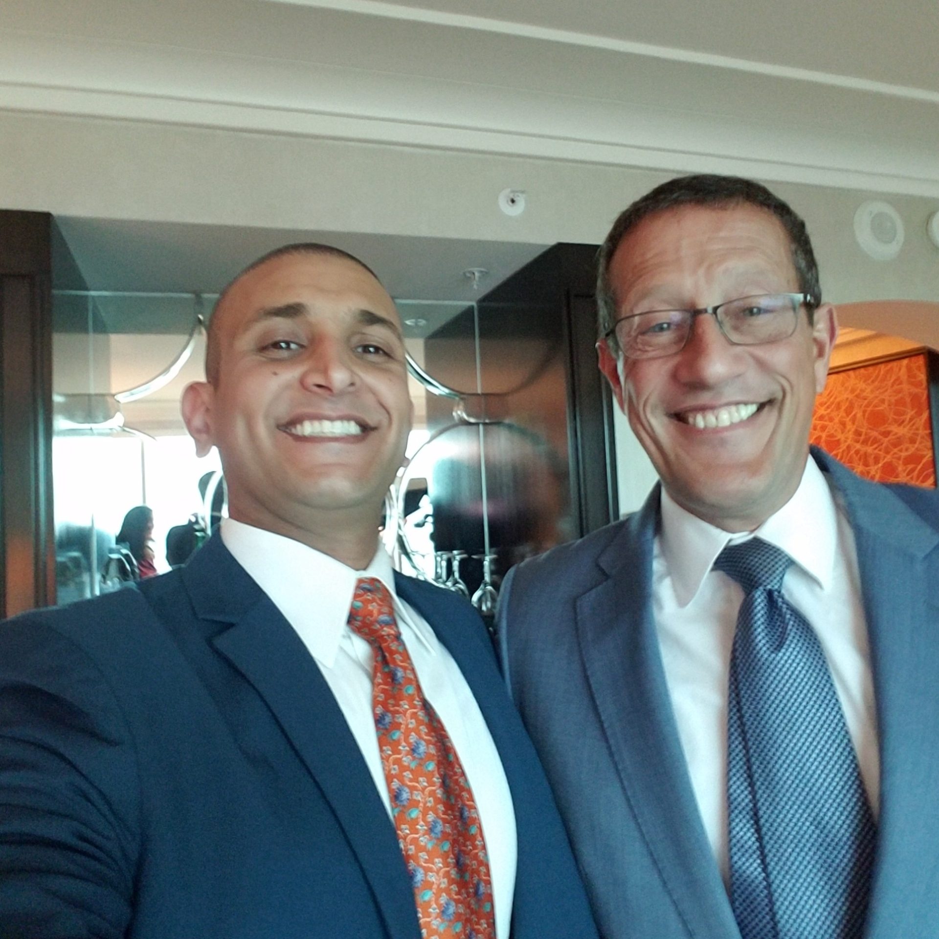two men in suits smiling for a selfie