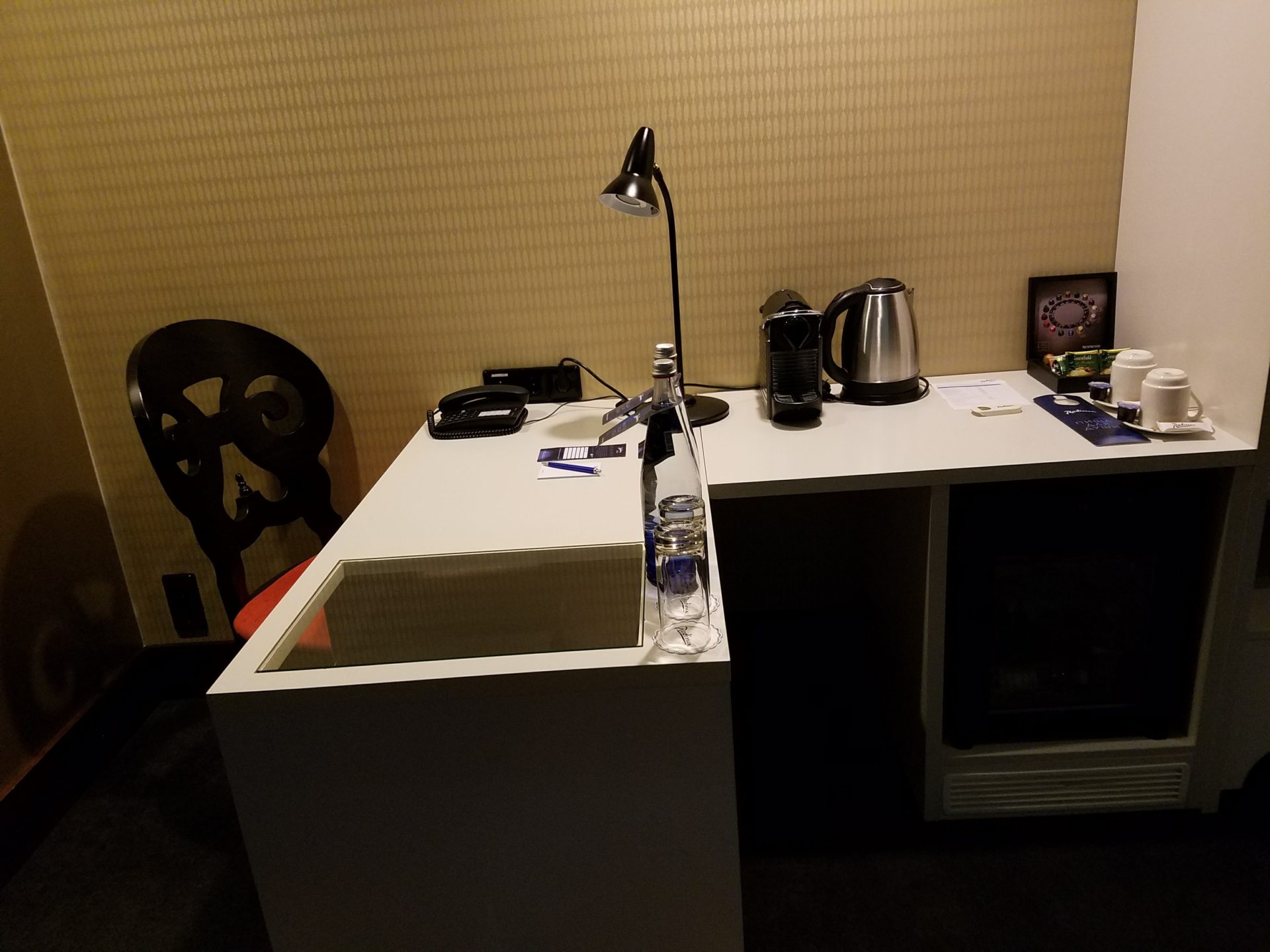 a desk with a lamp and a microwave