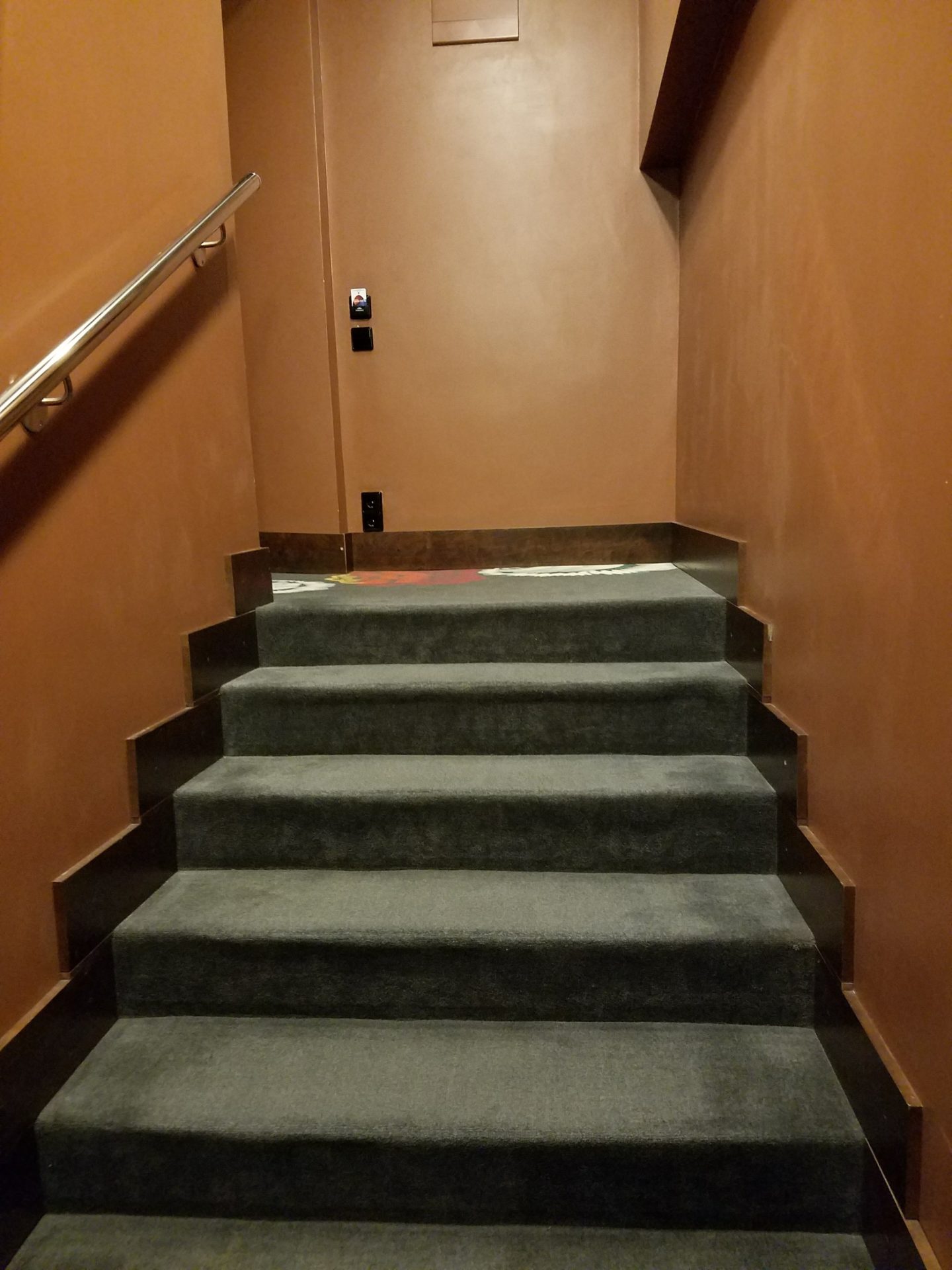 a staircase with a handrail and a door