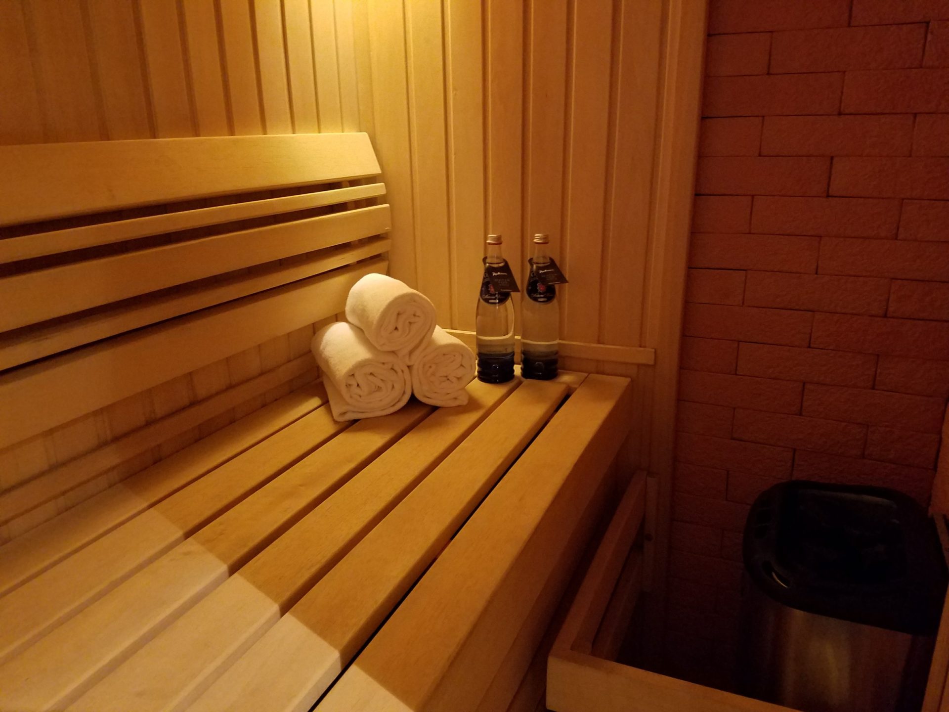 a wooden bench with towels and bottles of liquid