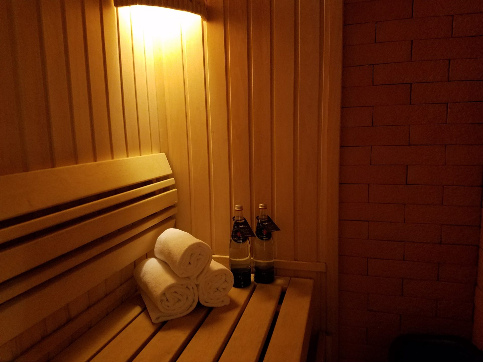 a wooden bench with towels and bottles on it