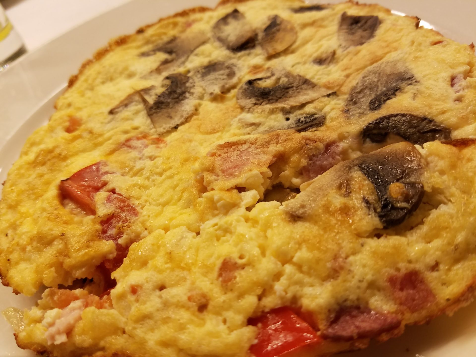 a plate of omelette with mushrooms and tomatoes