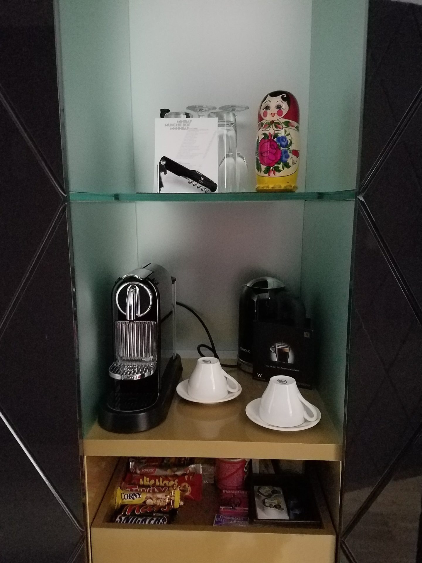 a shelf with a coffee machine and cups on it