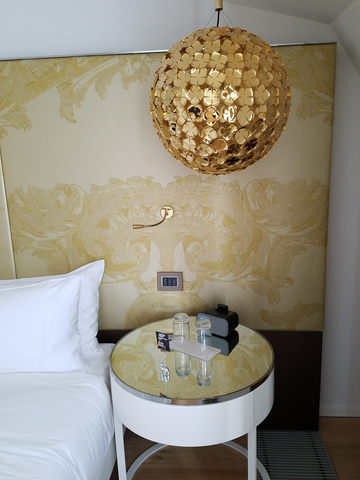 a bed with a round table and a gold ball from the ceiling