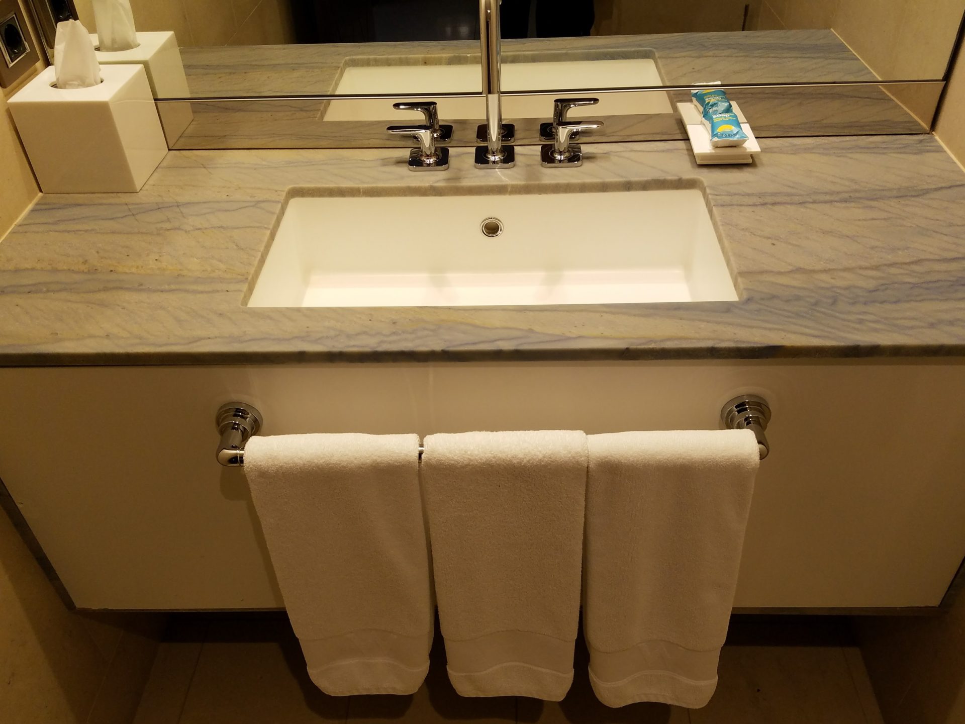 a bathroom sink with white towels on the wall