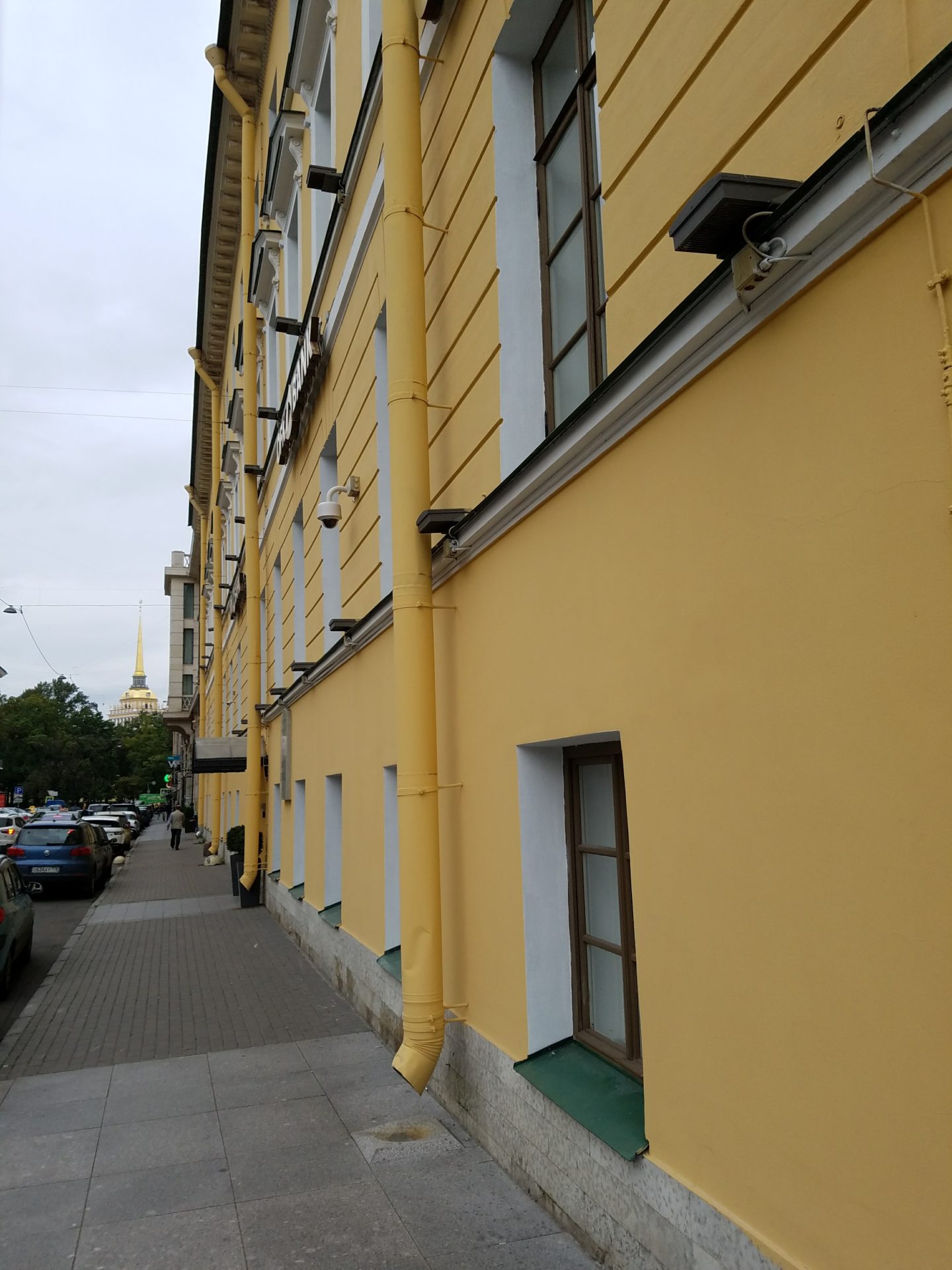 a yellow building with cars parked on the side