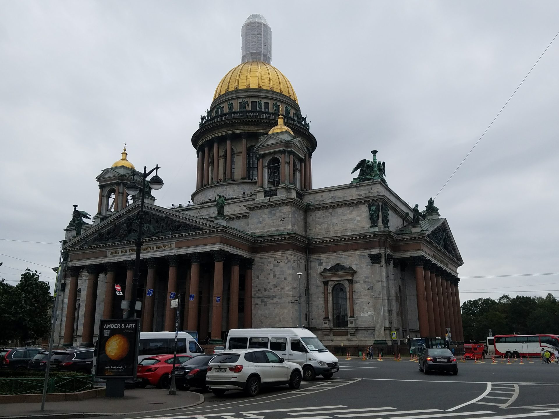 Saint Isaac's Cathedral with a dome on top and cars parked in front of it