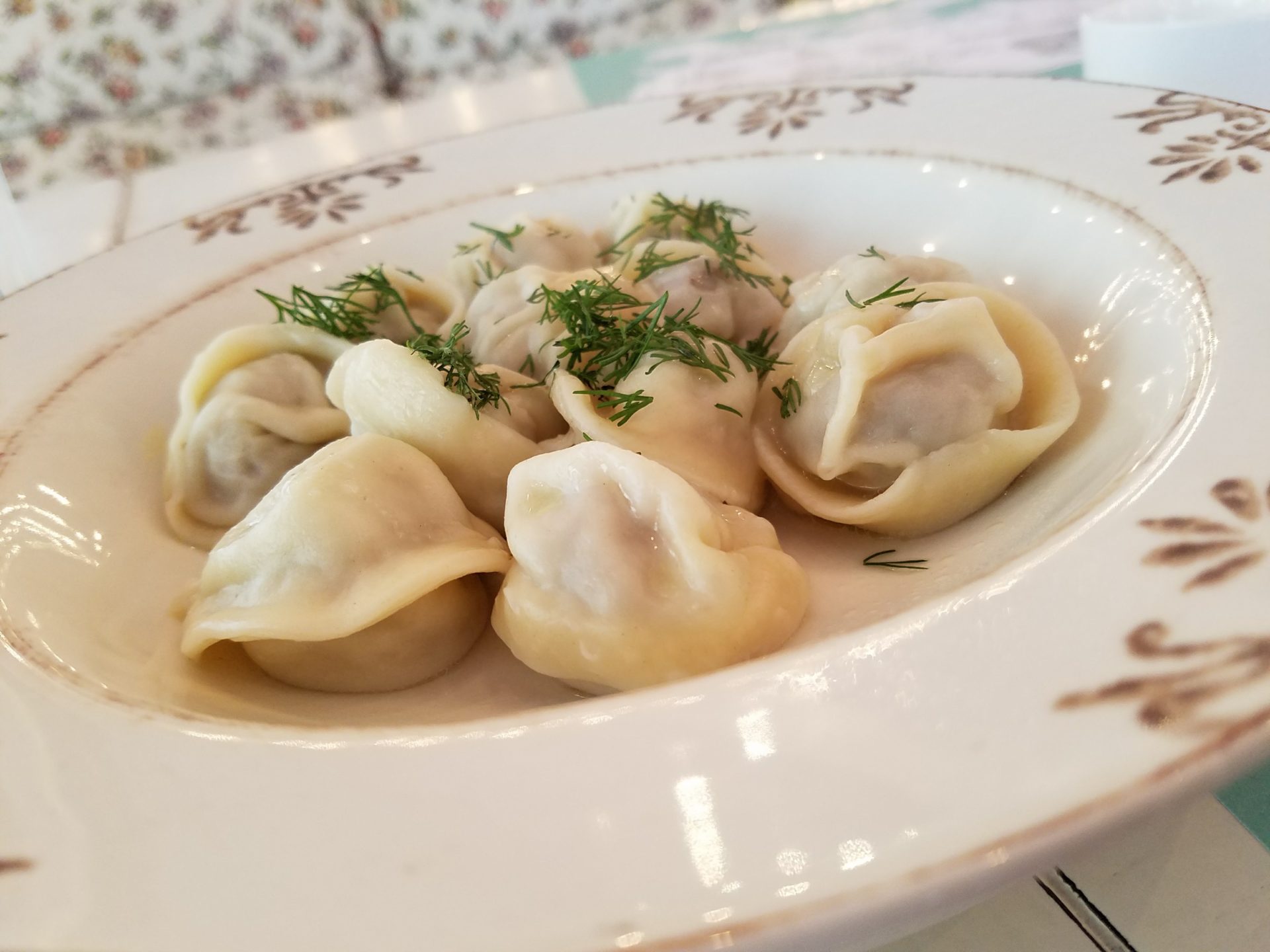a plate of dumplings with greens on it