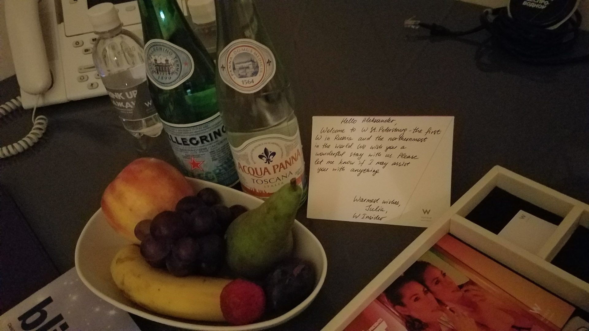 a bowl of fruit and a note on a table