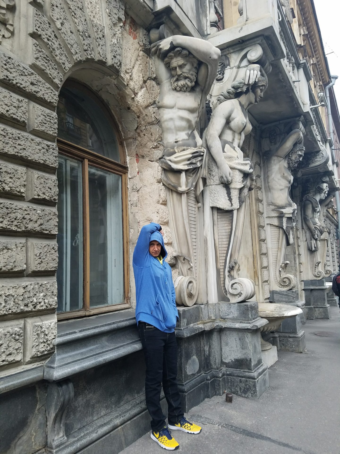 a person standing in front of a building with statues