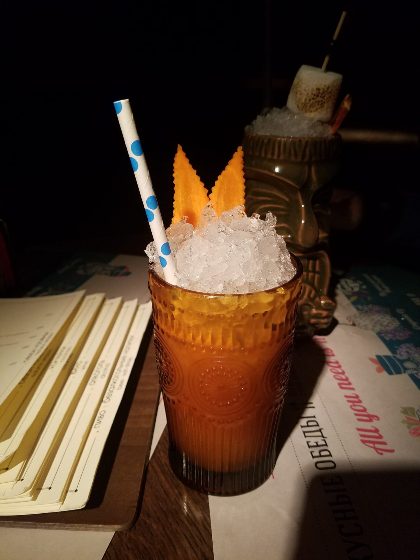 a glass with ice and orange liquid