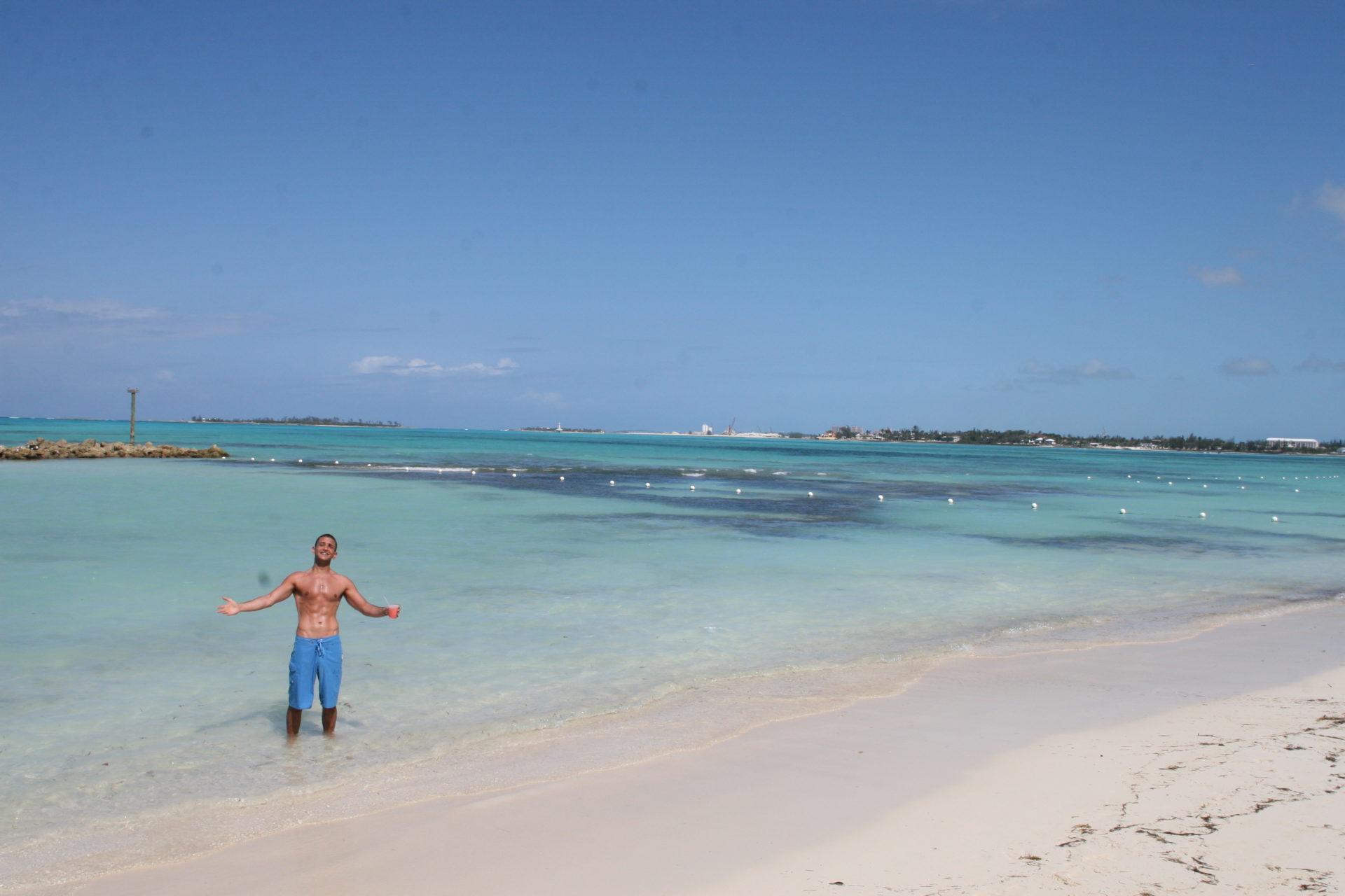 a man standing on a beach with his arms out