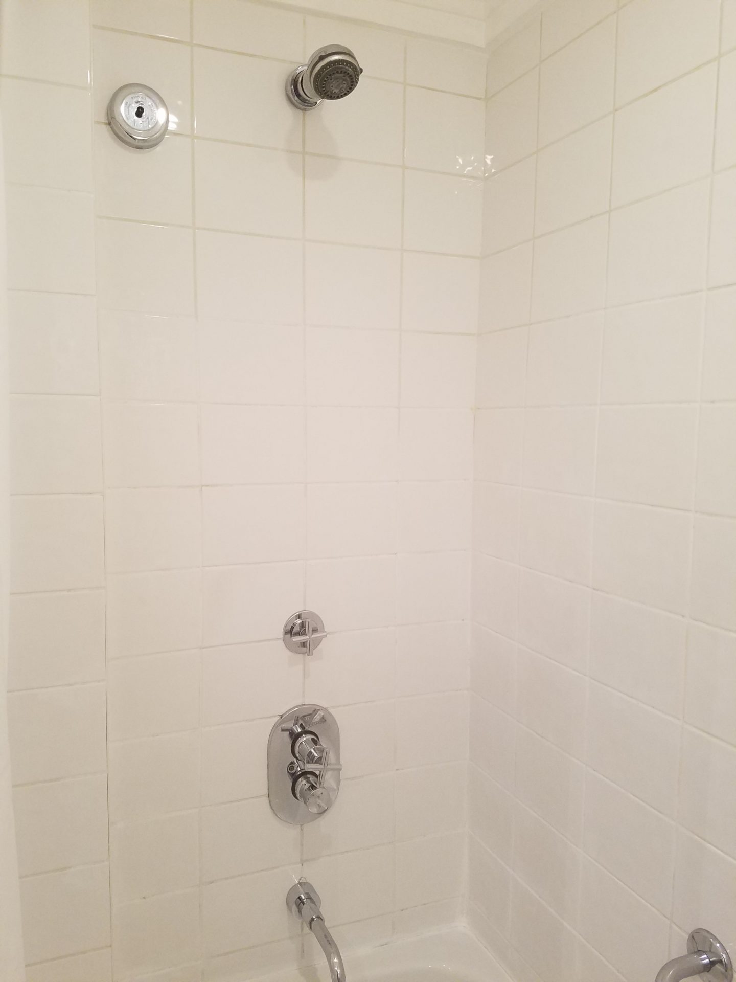 a shower with white tile