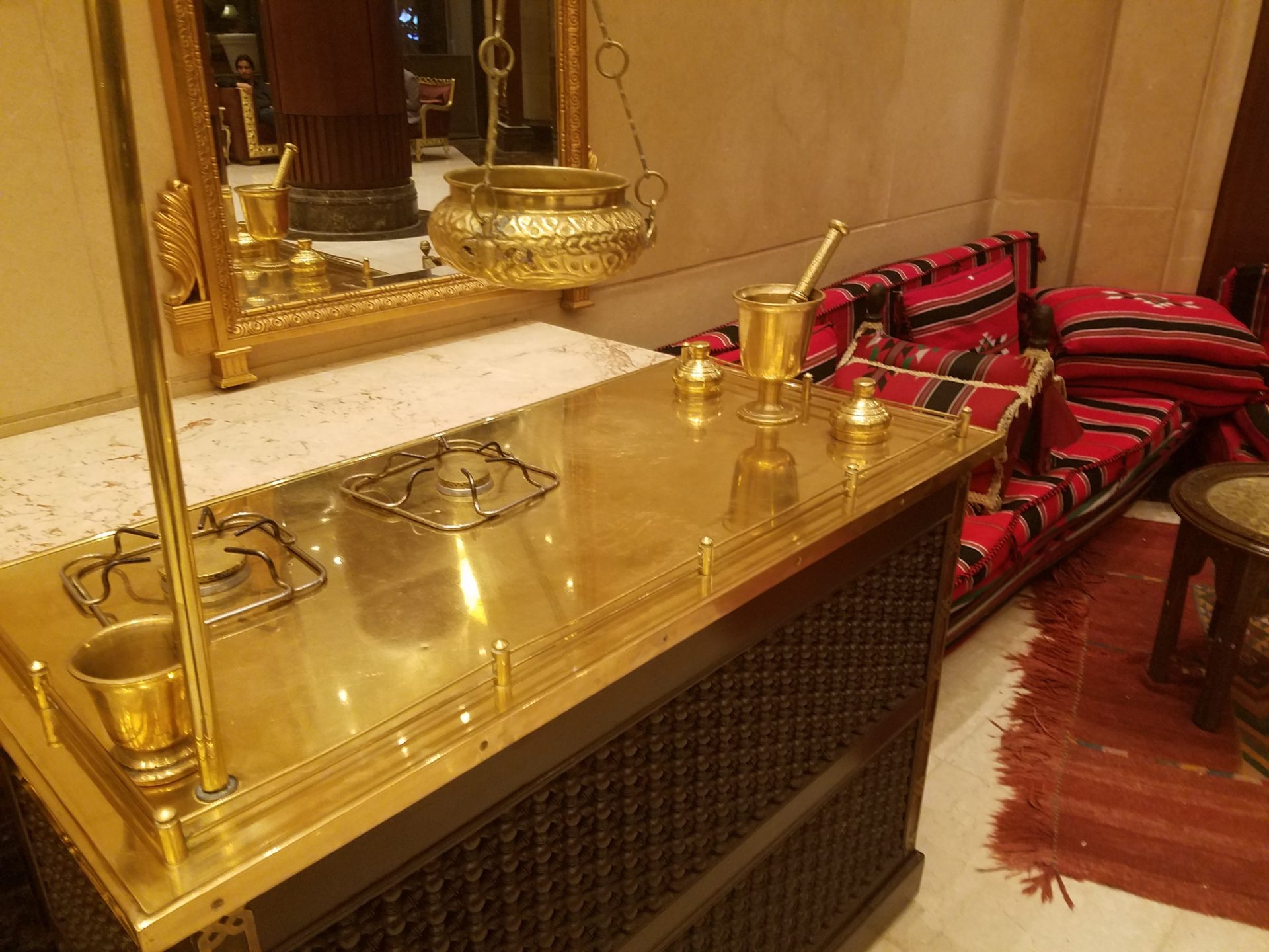 a gold counter top with a mirror and a pot on top