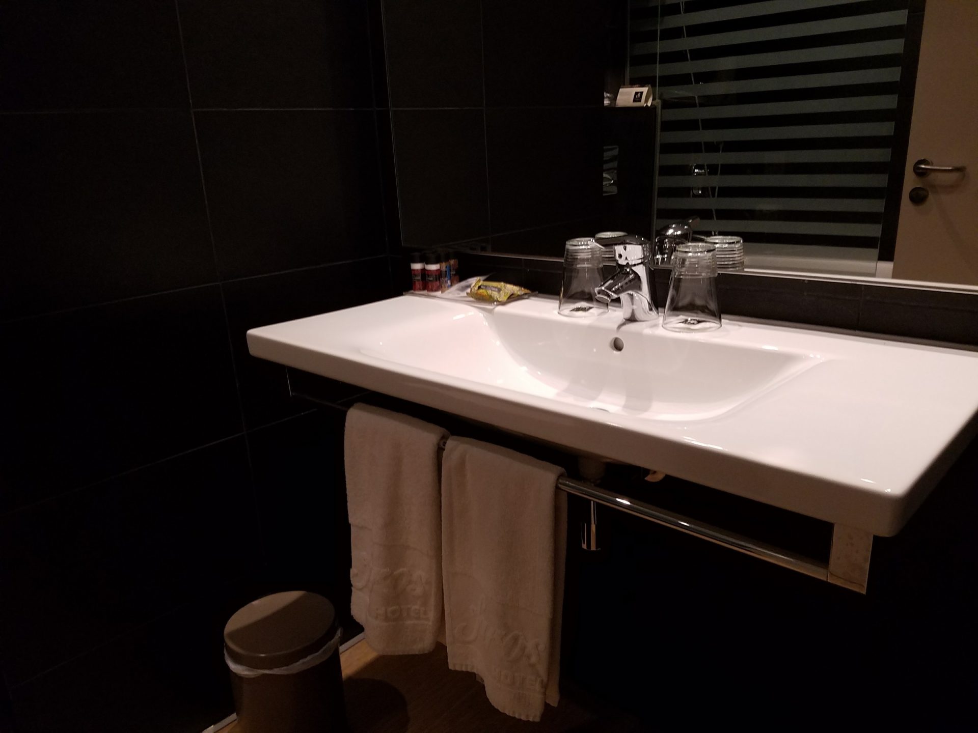 a bathroom sink with towels on the wall