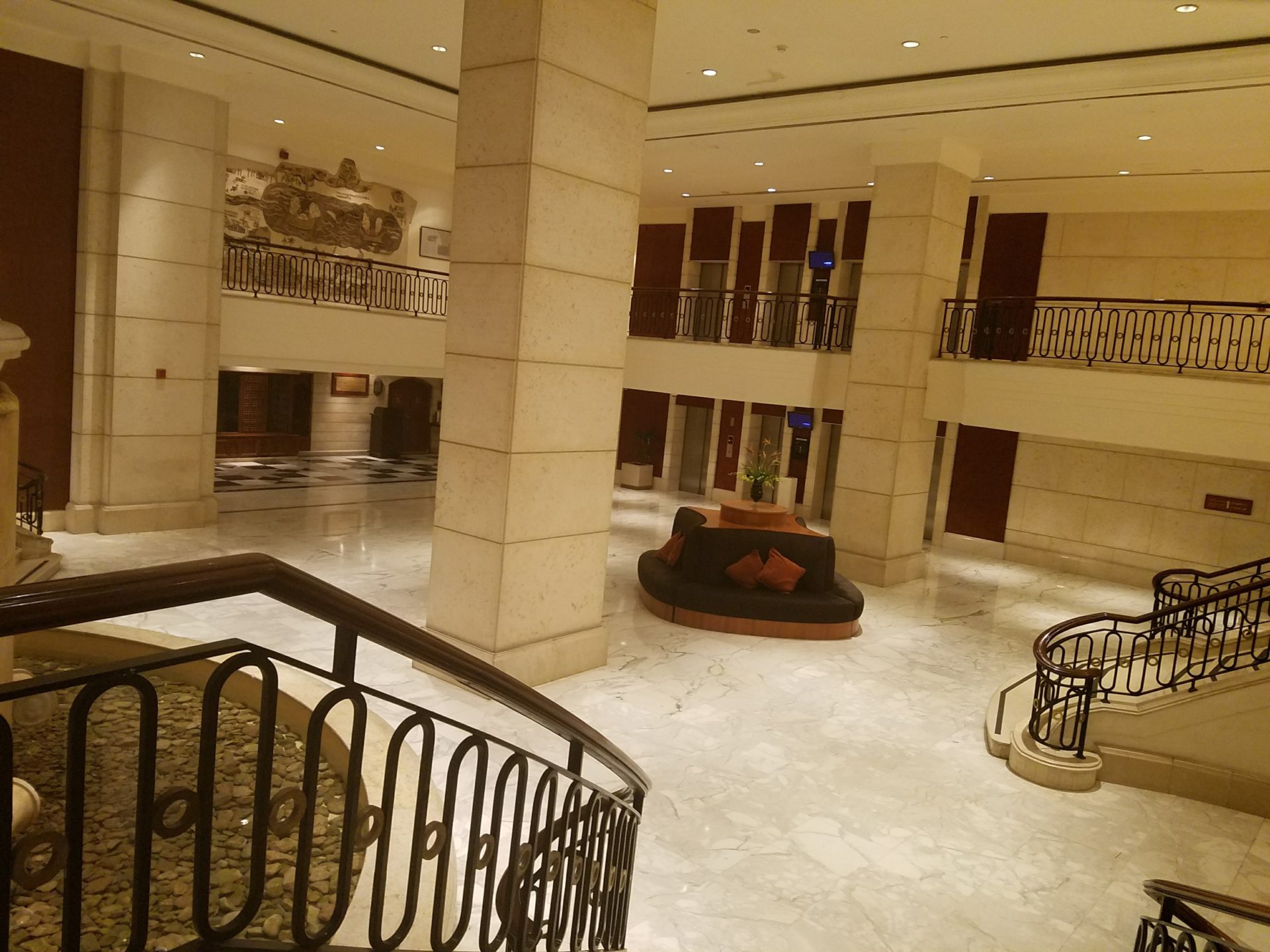 a large lobby with a staircase and a couch