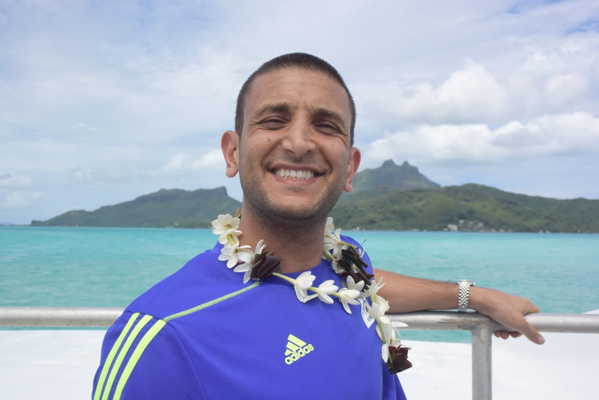 a man wearing a flower necklace on a boat