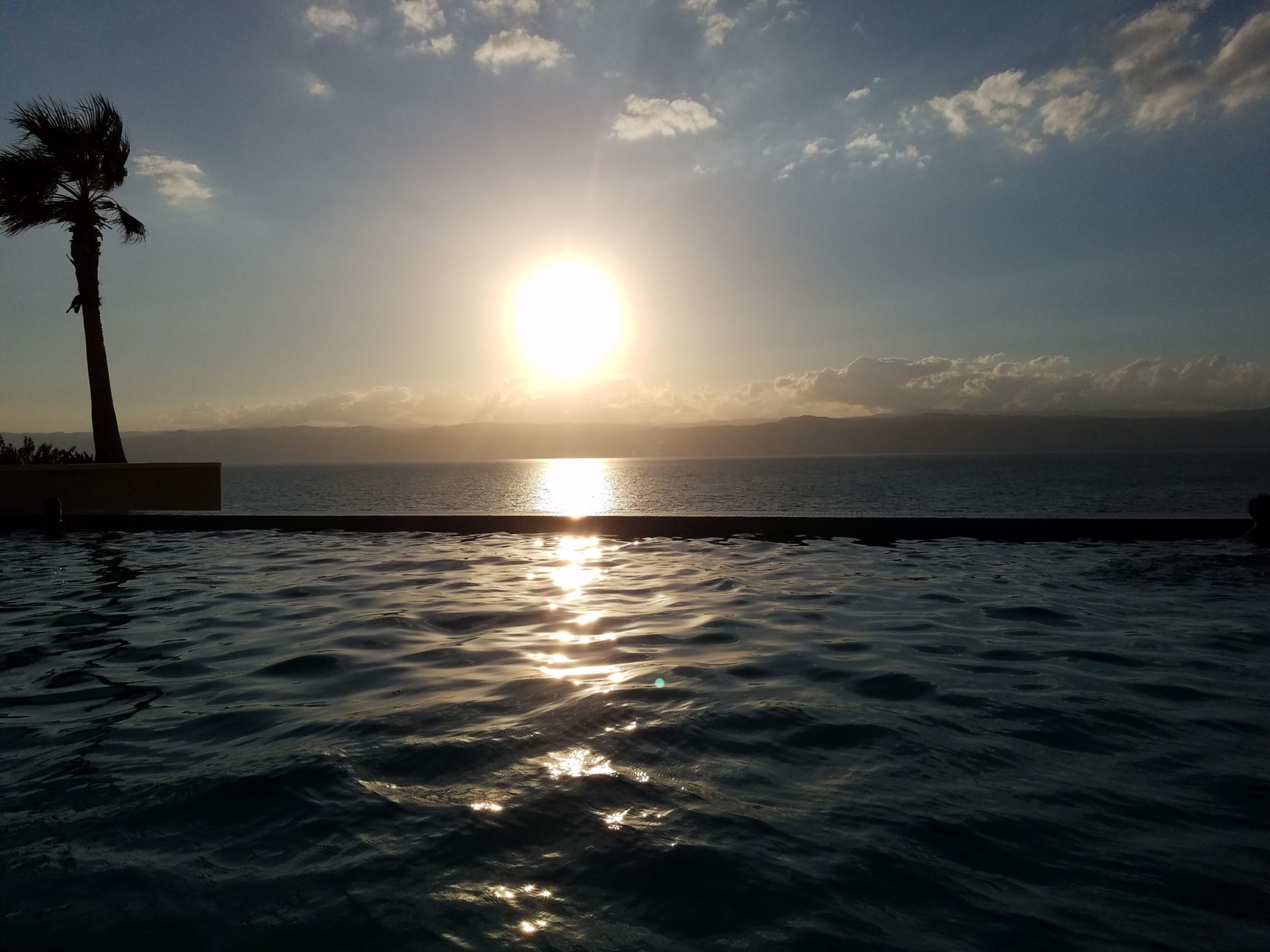 a body of water with the sun setting over it