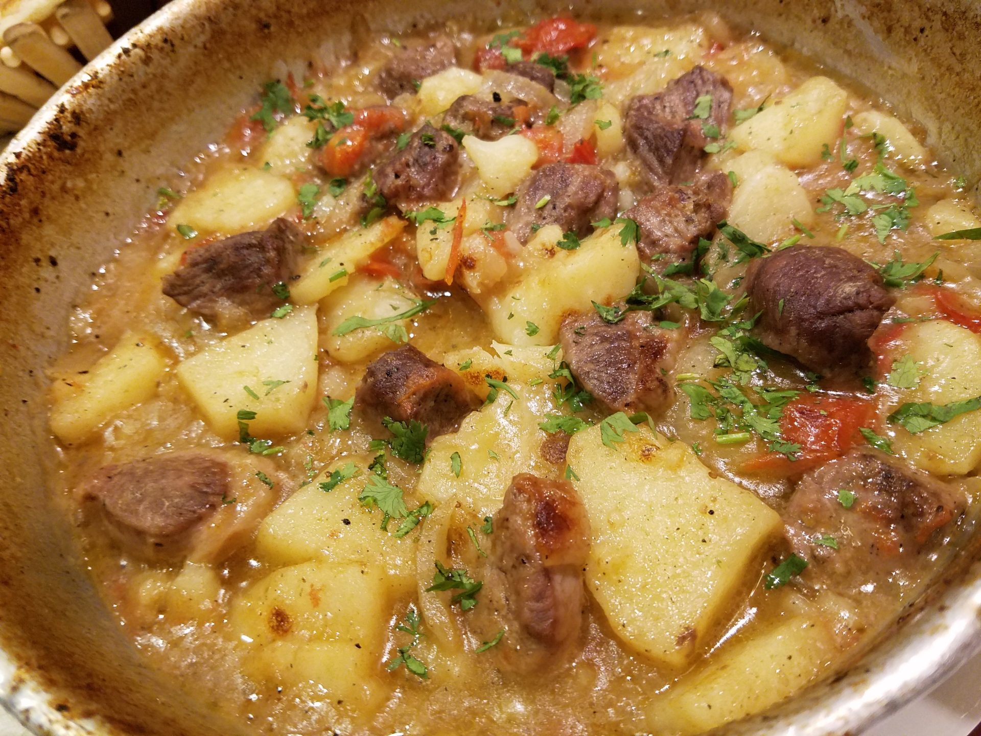 a bowl of food with meat and potatoes