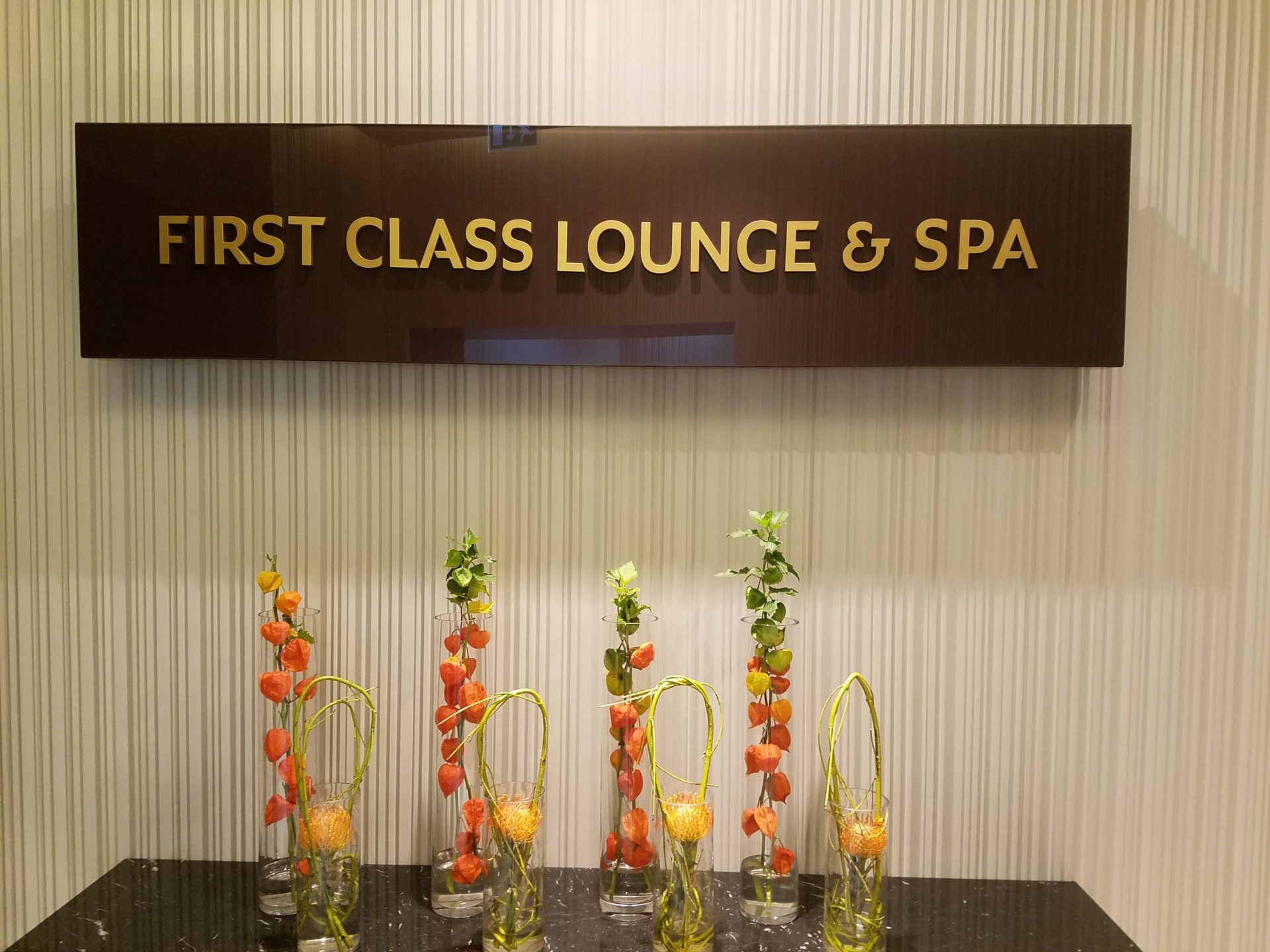 a group of vases with flowers in front of a sign