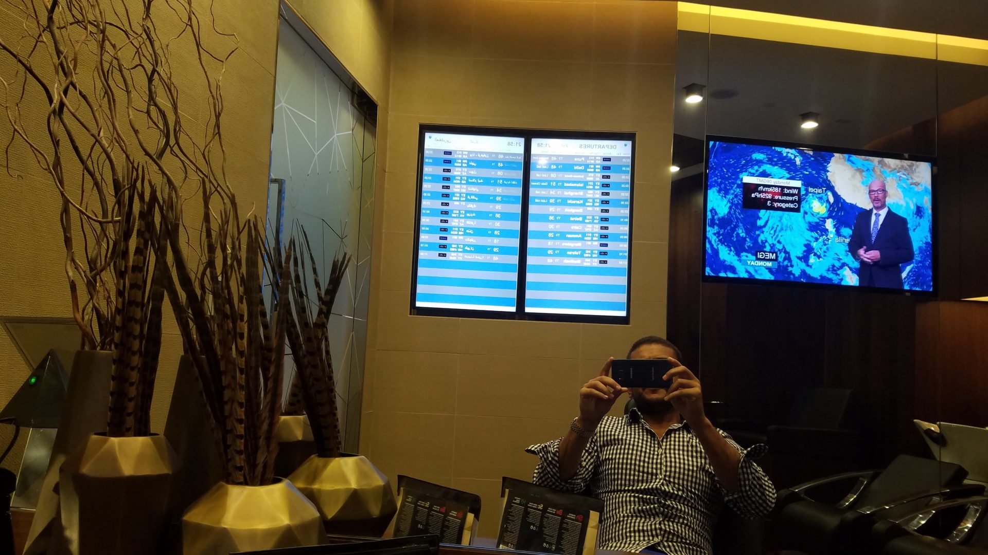 a man taking a picture of his flight schedule