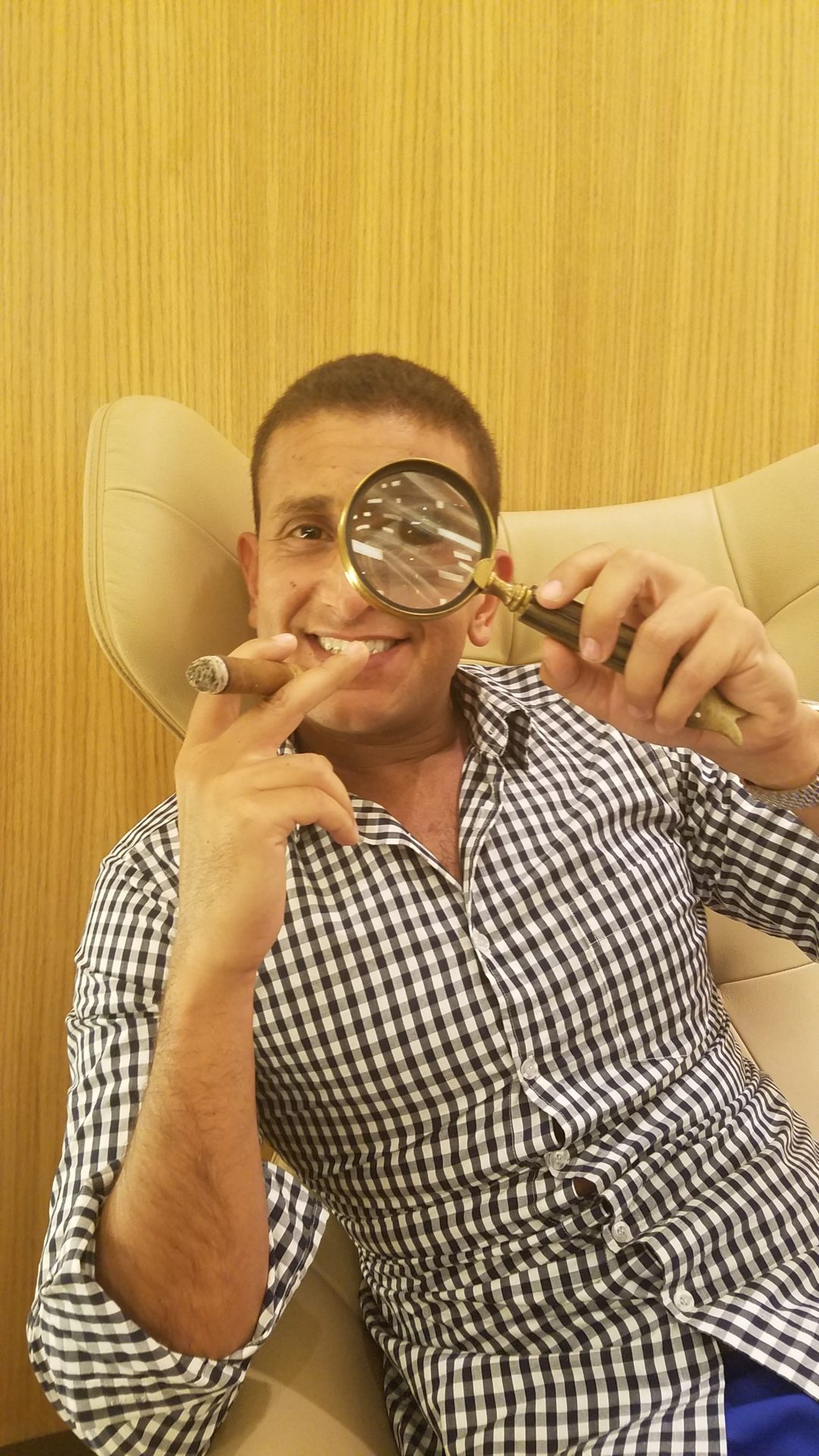 a man holding a magnifying glass and smoking a cigar