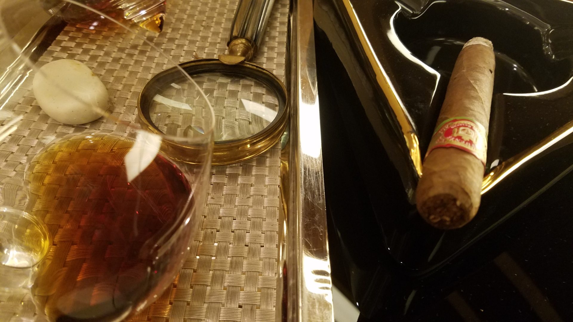 a cigar and a magnifying glass on a tray
