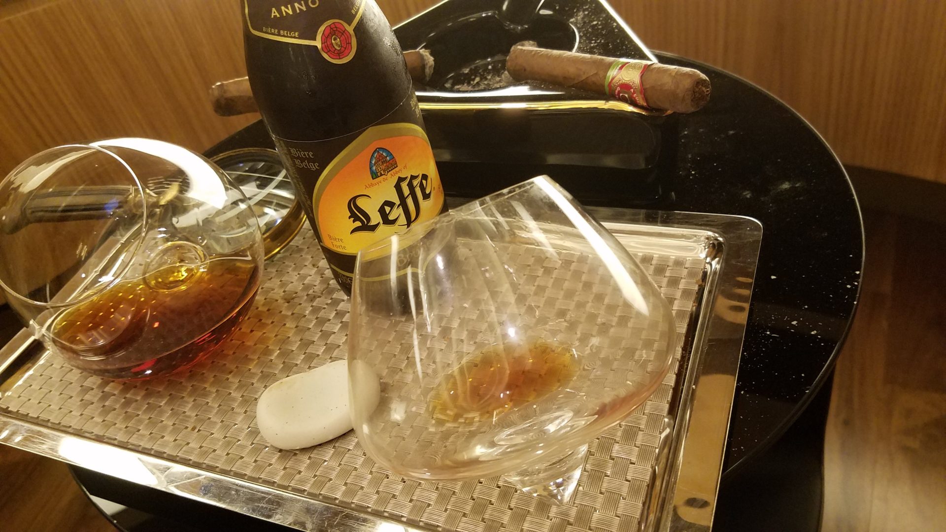 a glass and bottle of alcohol on a tray