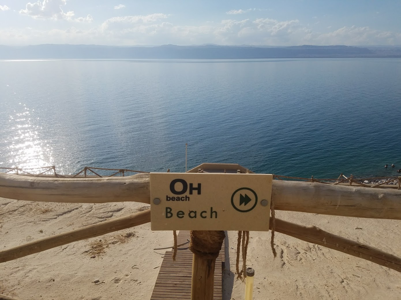 a sign on a wooden fence overlooking a body of water