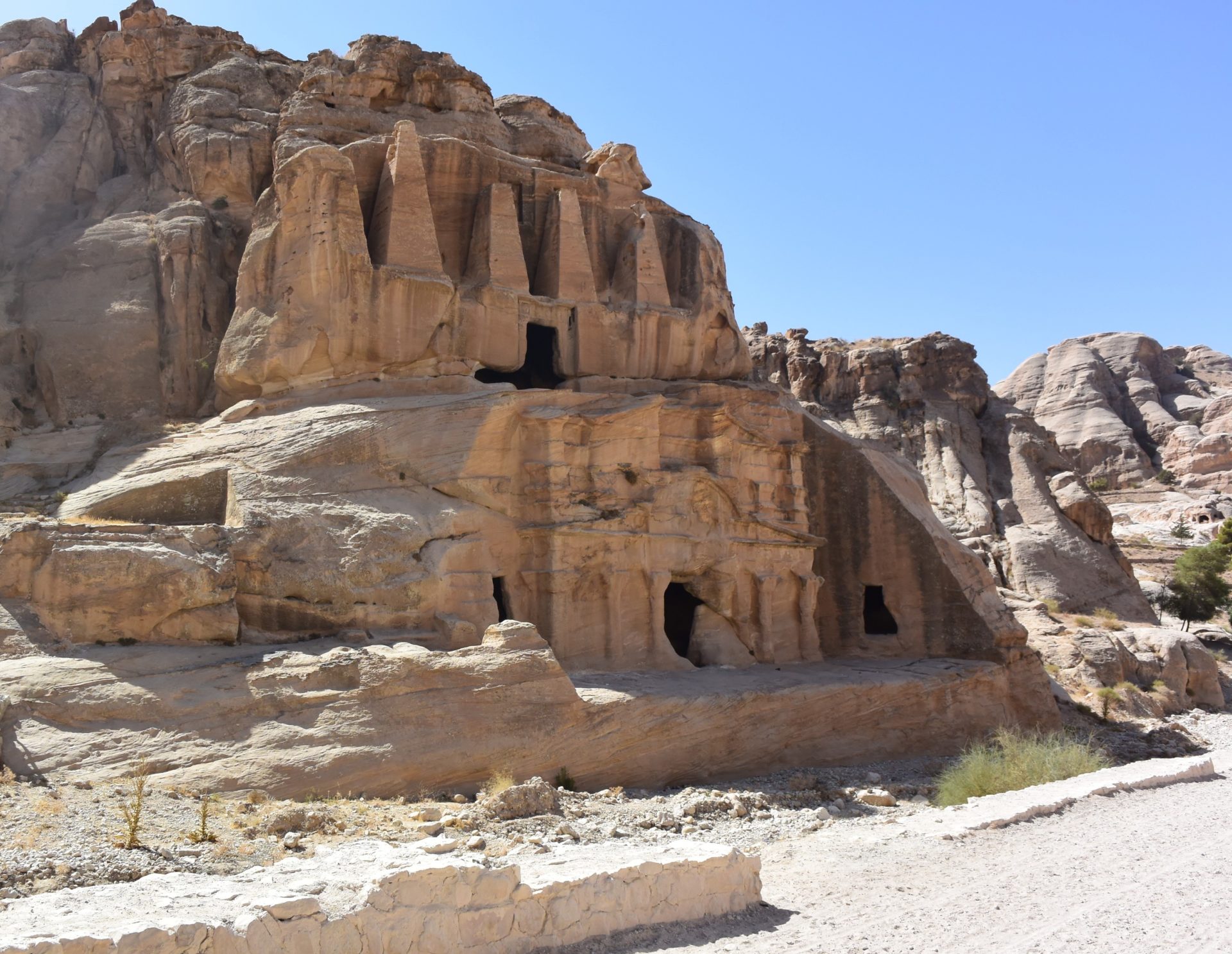 a rock structure in the desert with Petra in the background