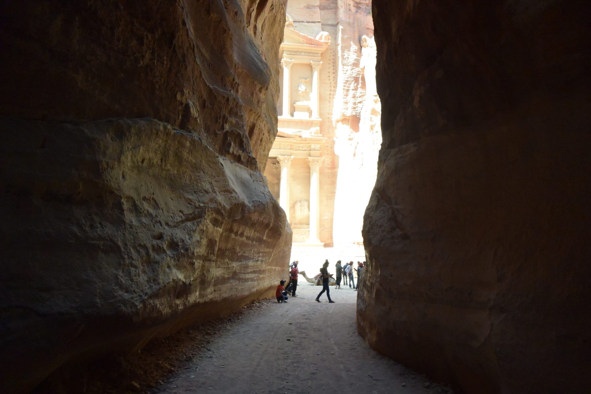 a group of people walking through a canyon