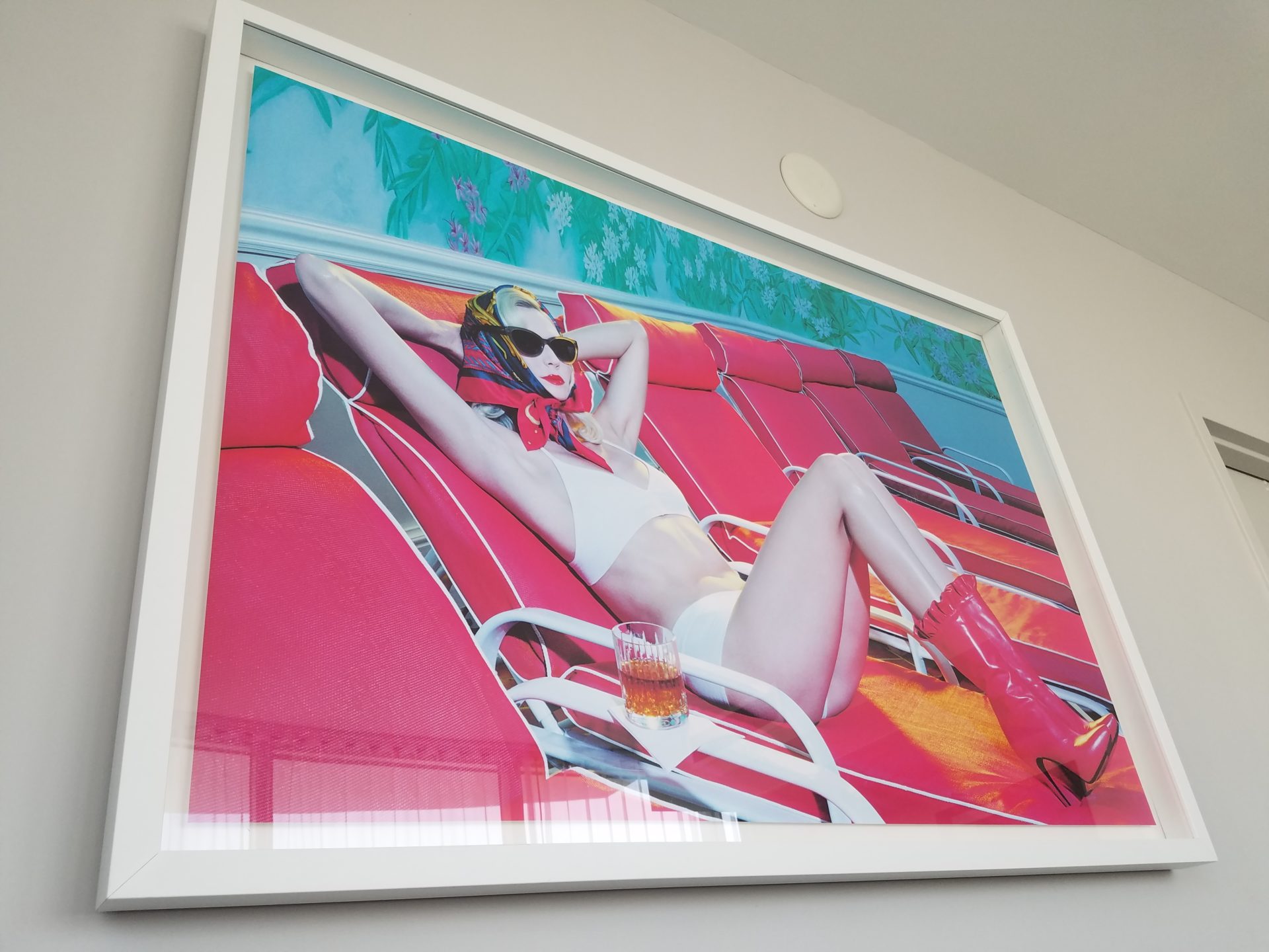 a framed picture of a woman in a garment on a red couch